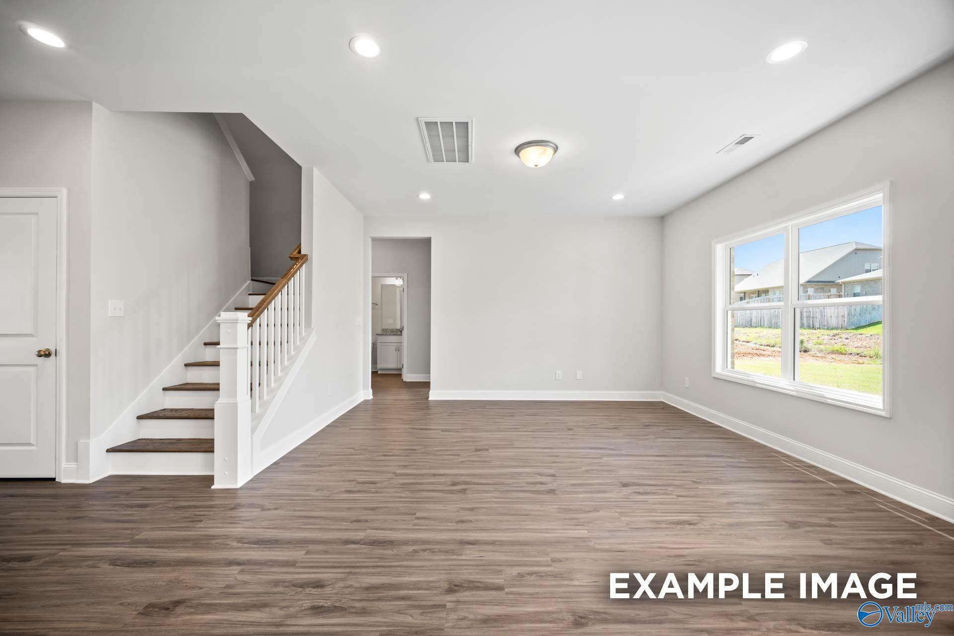 Bright, open-concept living area with wood-style flooring in The Shelby B floor plan at Jaguar Hills, Huntsville, Alabama.