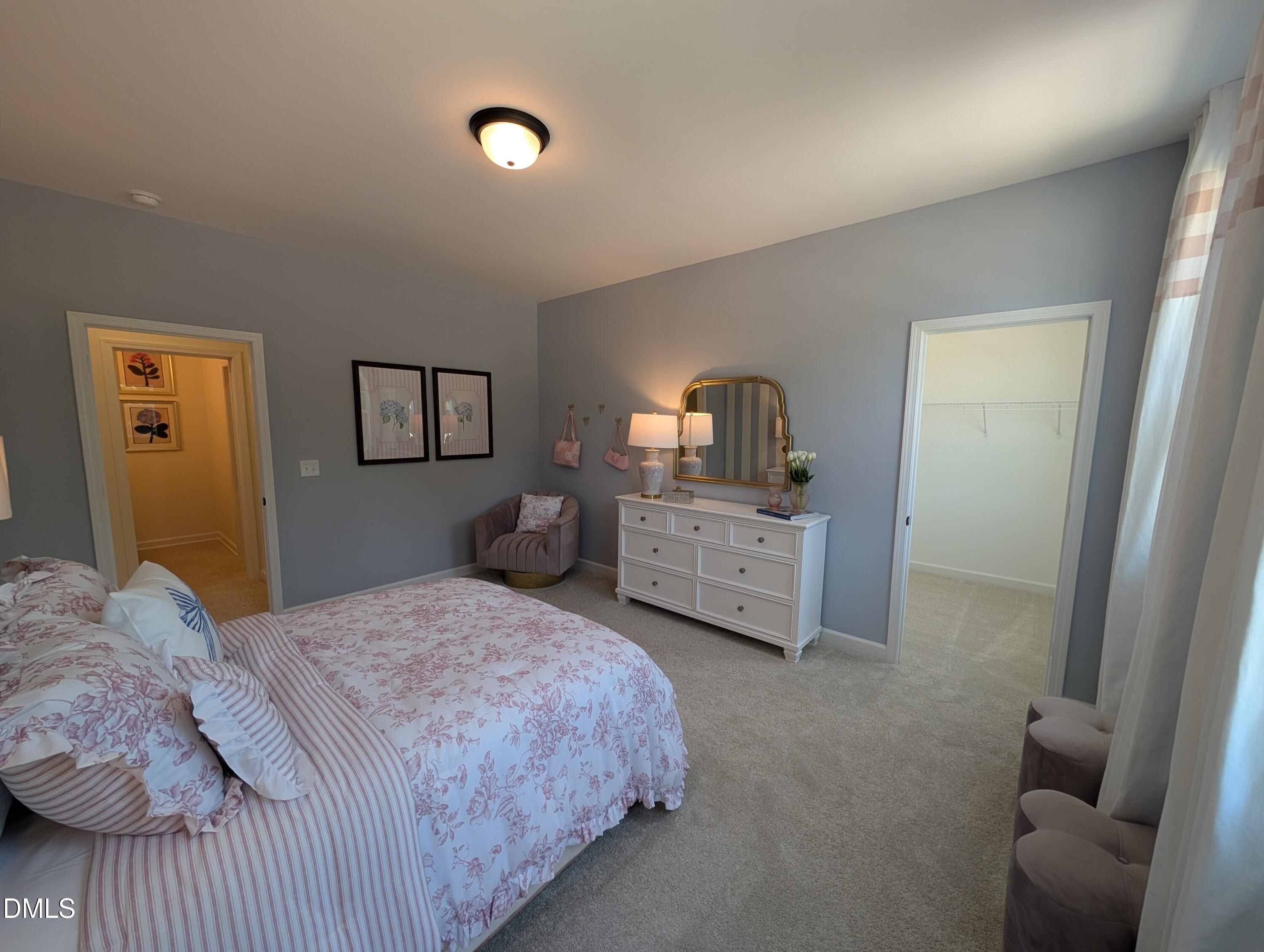 Cozy bedroom with floral bedding and walk-in closet in The Aspen B floor plan at Wendell Ridge, Wendell, North Carolina.
