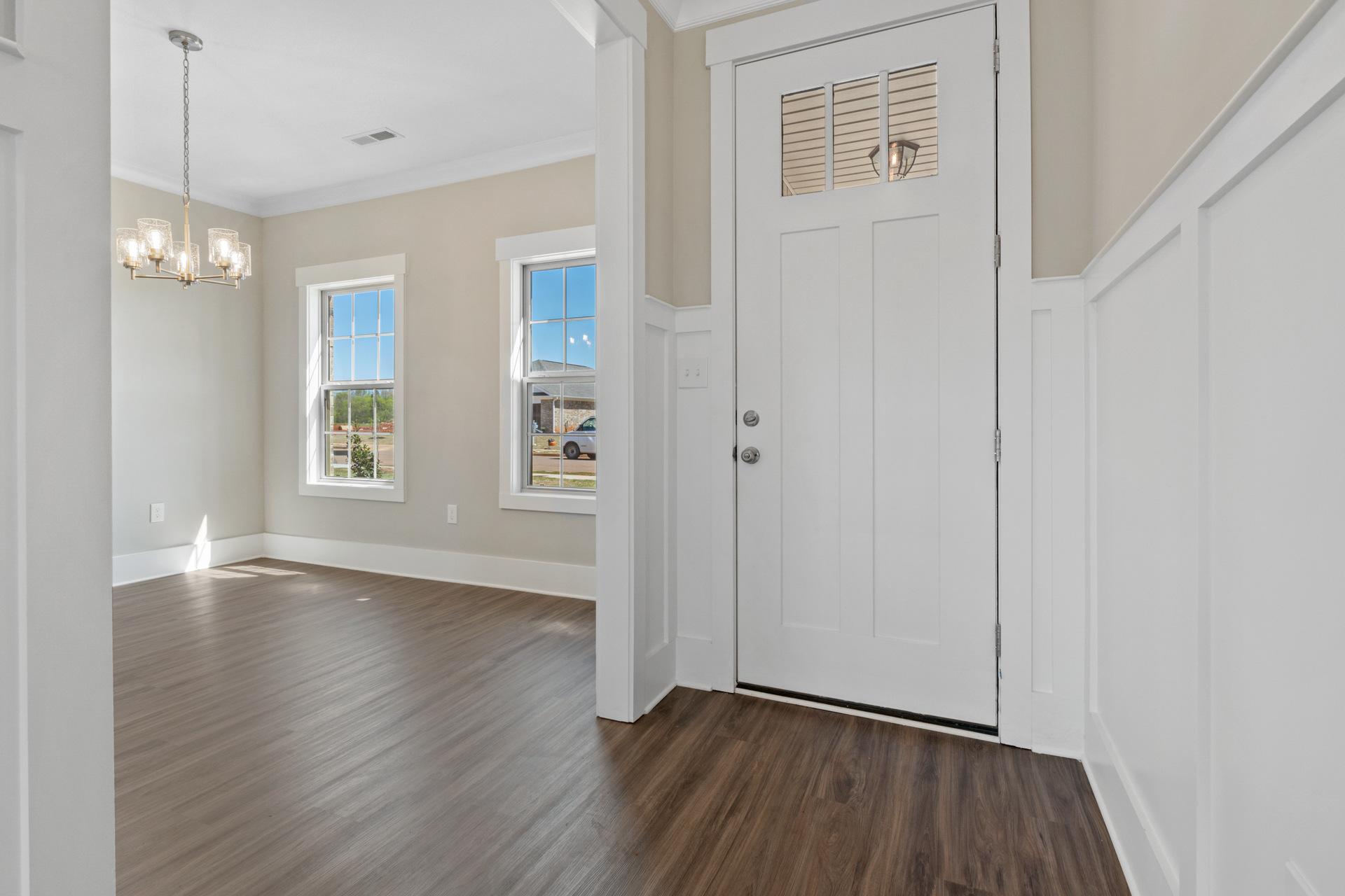 Bright entry foyer at Little Burwell Estates in Harvest Alabama with chandelier, hardwood floors, and large windows