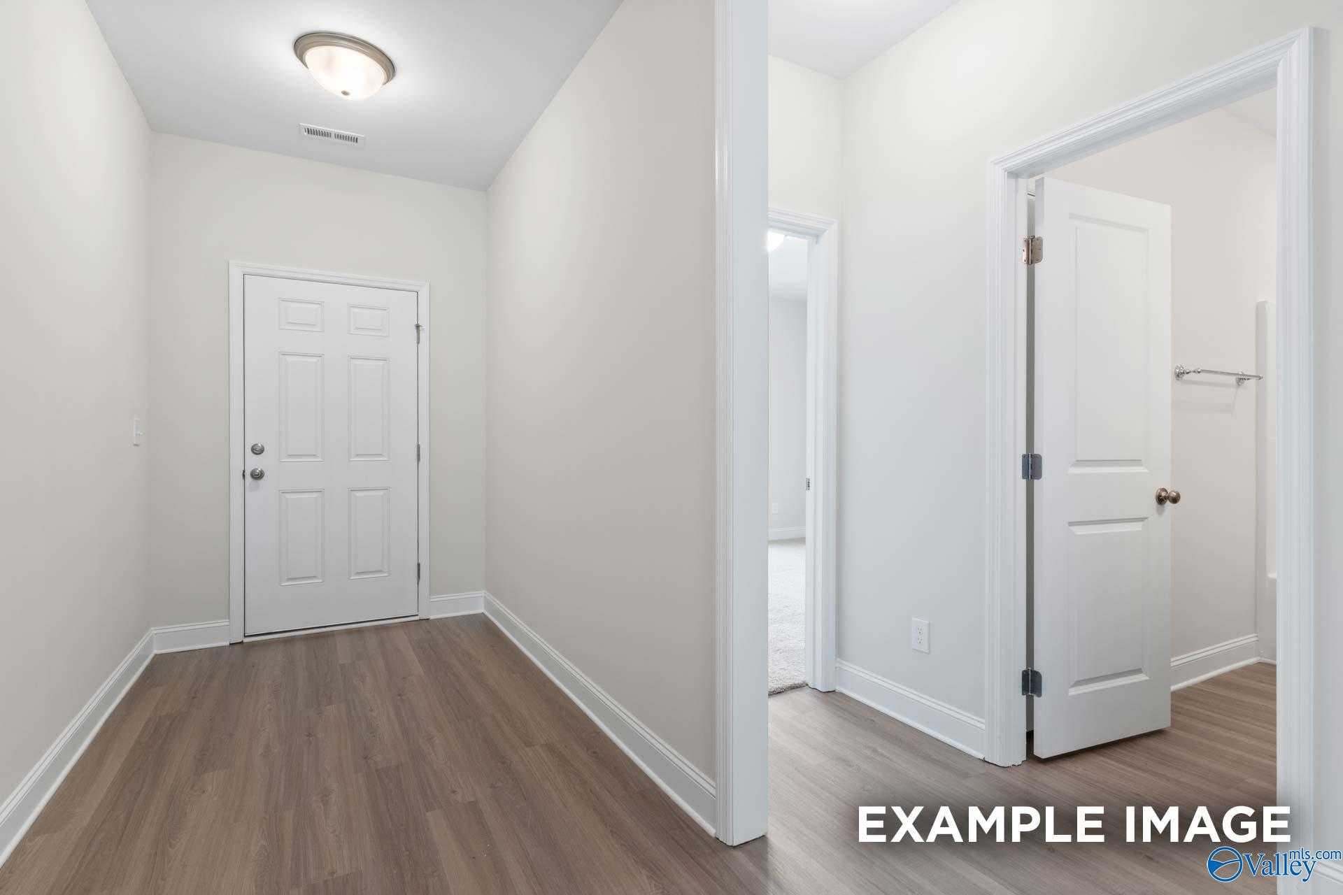 Bright hallway with luxury vinyl plank floors, white doors, and walk-in closet in The Daphne D 4-bedroom home, The Highlands, Arab, Alabama
