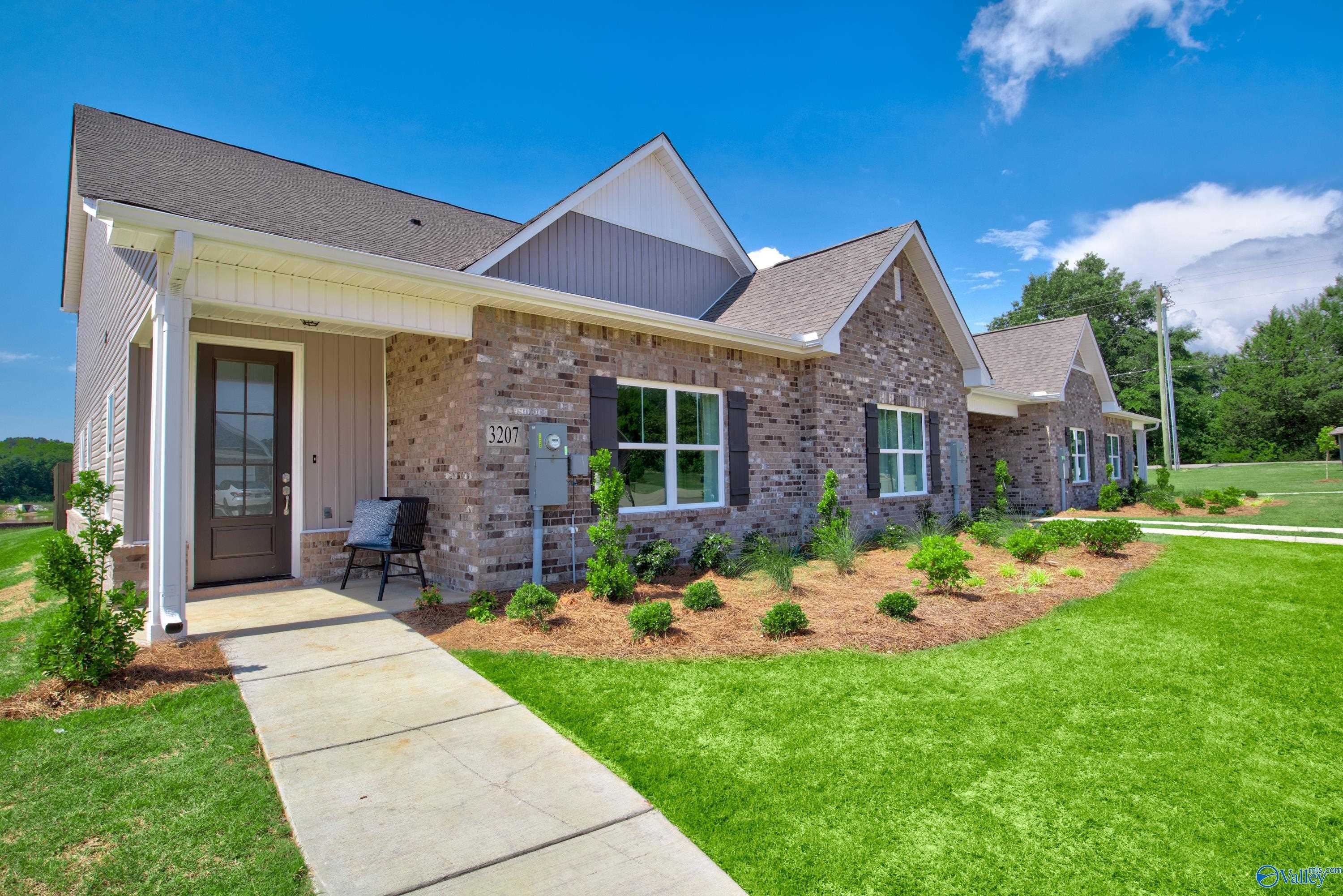 Two-story brick Davidson Homes The Covington C with covered front porch, shutters, and landscaped yard in River Road Estates, Decatur, Alabama