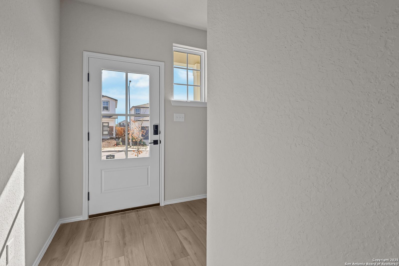 Bright front entry door with sidelight window overlooking neighborhood in Davidson Homes The Brazos C, San Antonio