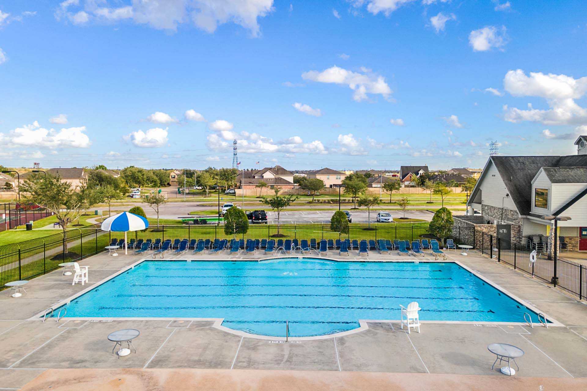 Resort-style swimming pool at Sierra Vista in Rosharon Texas with lounge chairs umbrellas and sundeck