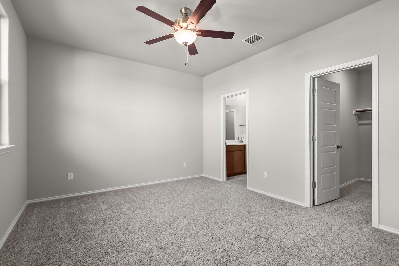 Spacious secondary bedroom with ceiling fan, ensuite bathroom, and walk-in closet in Davidson Homes The Frio G floor plan.