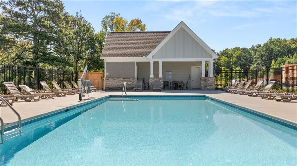 Community swimming pool with lounge chairs and pool house pavilion at Lake Shore by Davidson Homes in Winder, Georgia