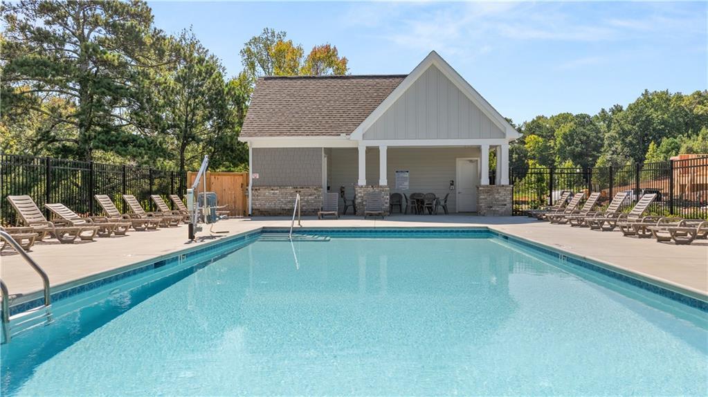 Community swimming pool with lounge chairs and pool house pavilion at Lake Shore by Davidson Homes in Winder, Georgia