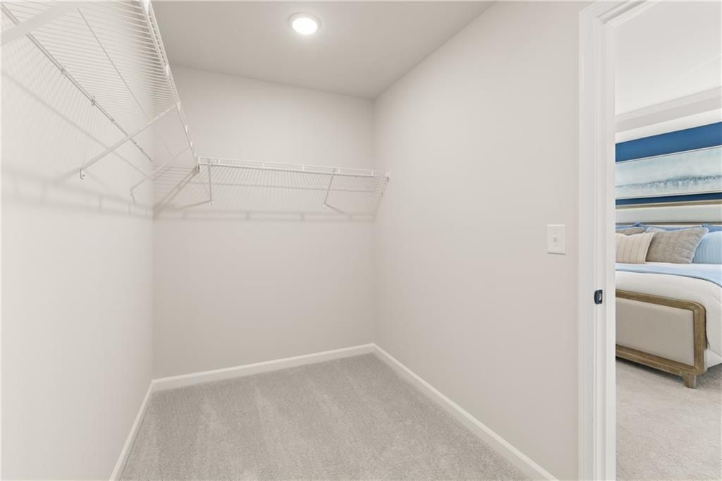 Spacious walk-in closet with wire shelving and rods in master bedroom of Davidson Homes The Burton C, Canton, Georgia