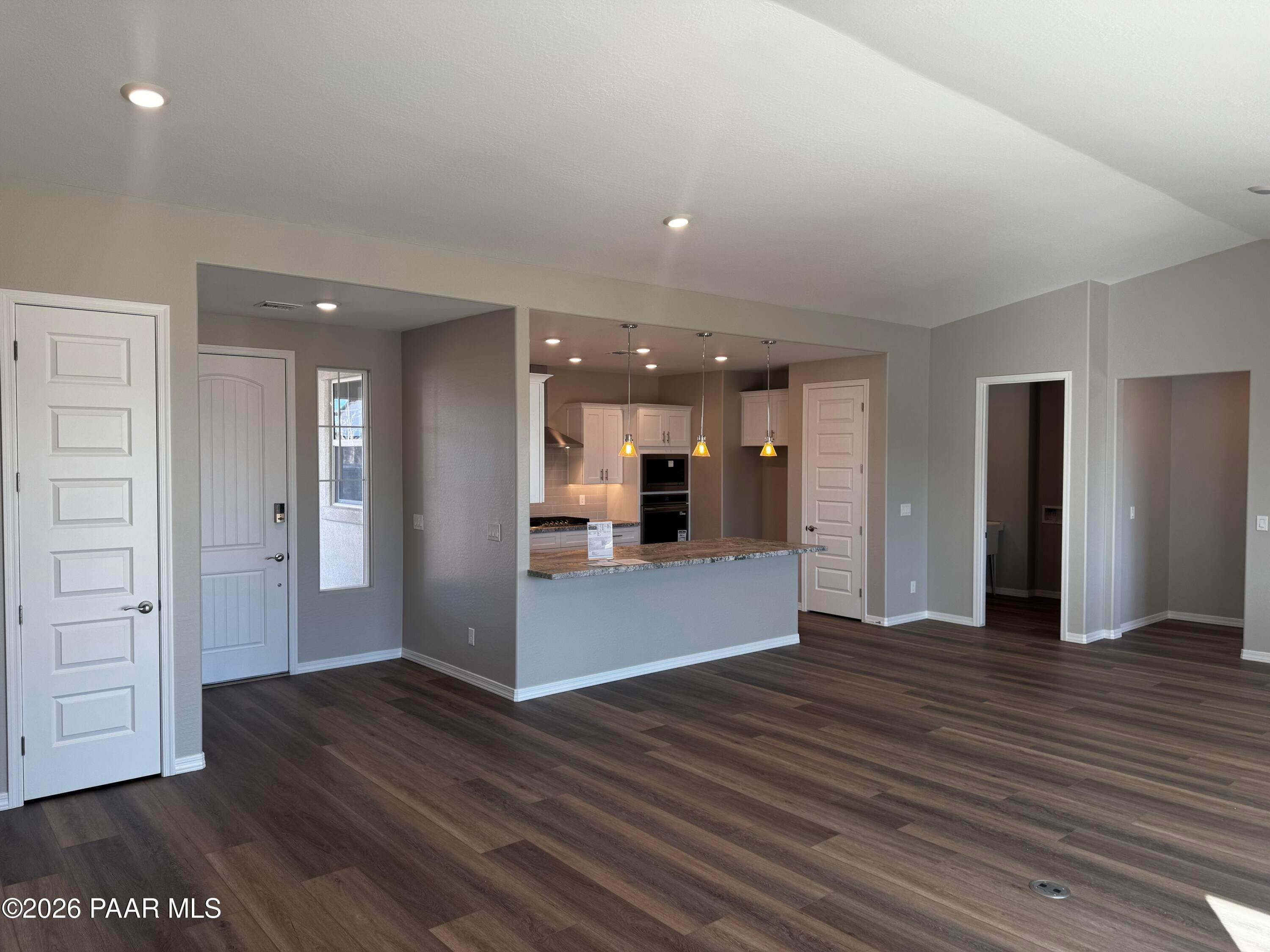 Open entryway with white door, kitchen island, and interior bedrooms in Davidson Homes Daybreak B, Prescott AZ