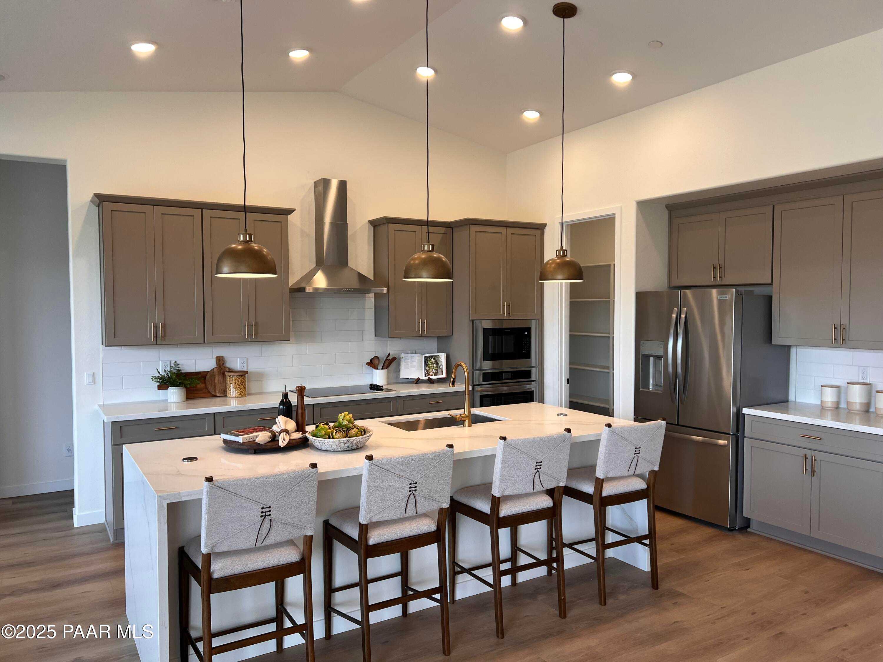 Modern kitchen with quartz island, stainless appliances, and pendant lights in Davidson Homes The Blaze D, Prescott, Arizona