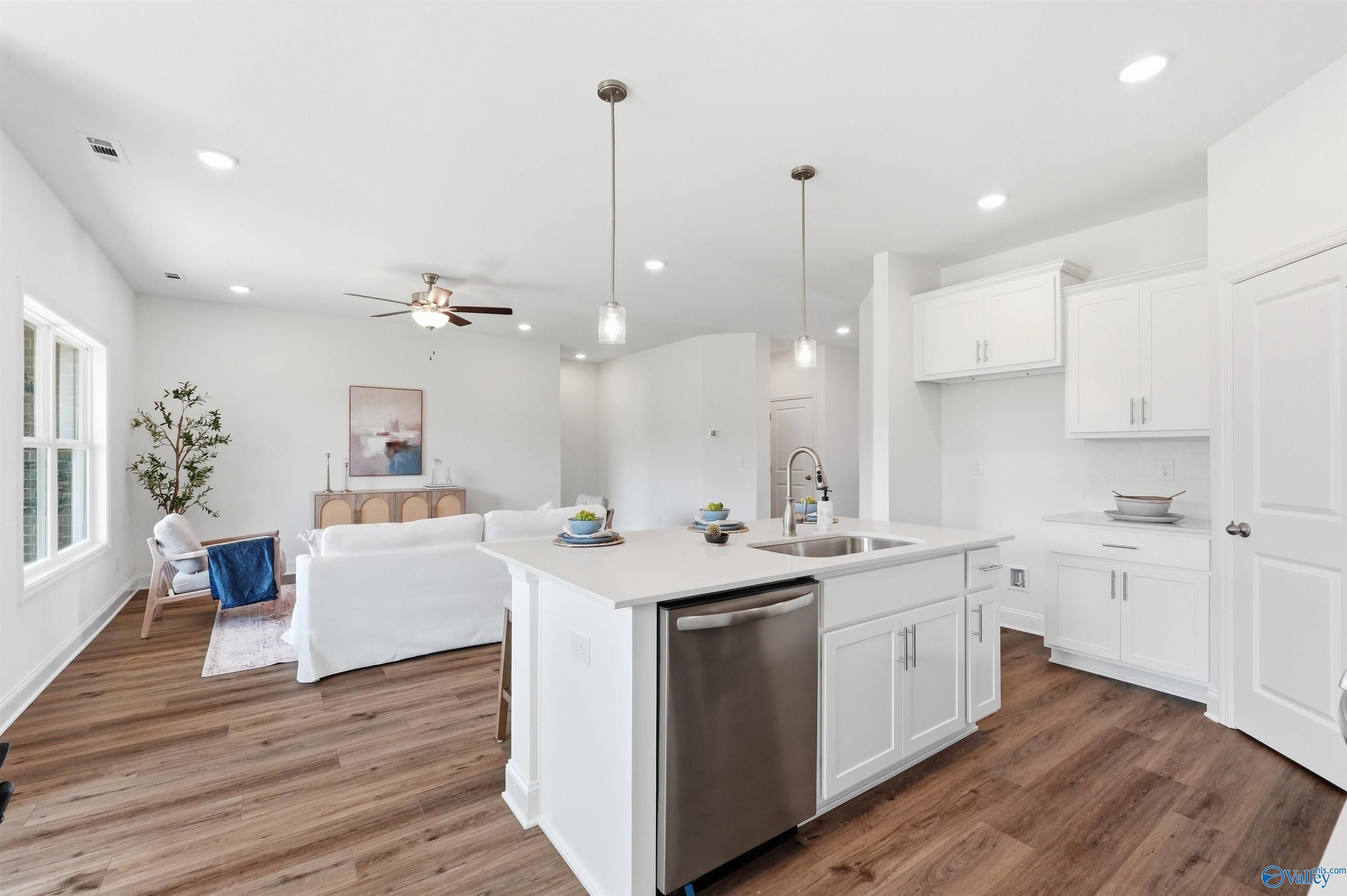 Open-concept kitchen with white cabinets and island in The Franklin C floor plan at Lynn Meadows, Meridianville, Alabama.