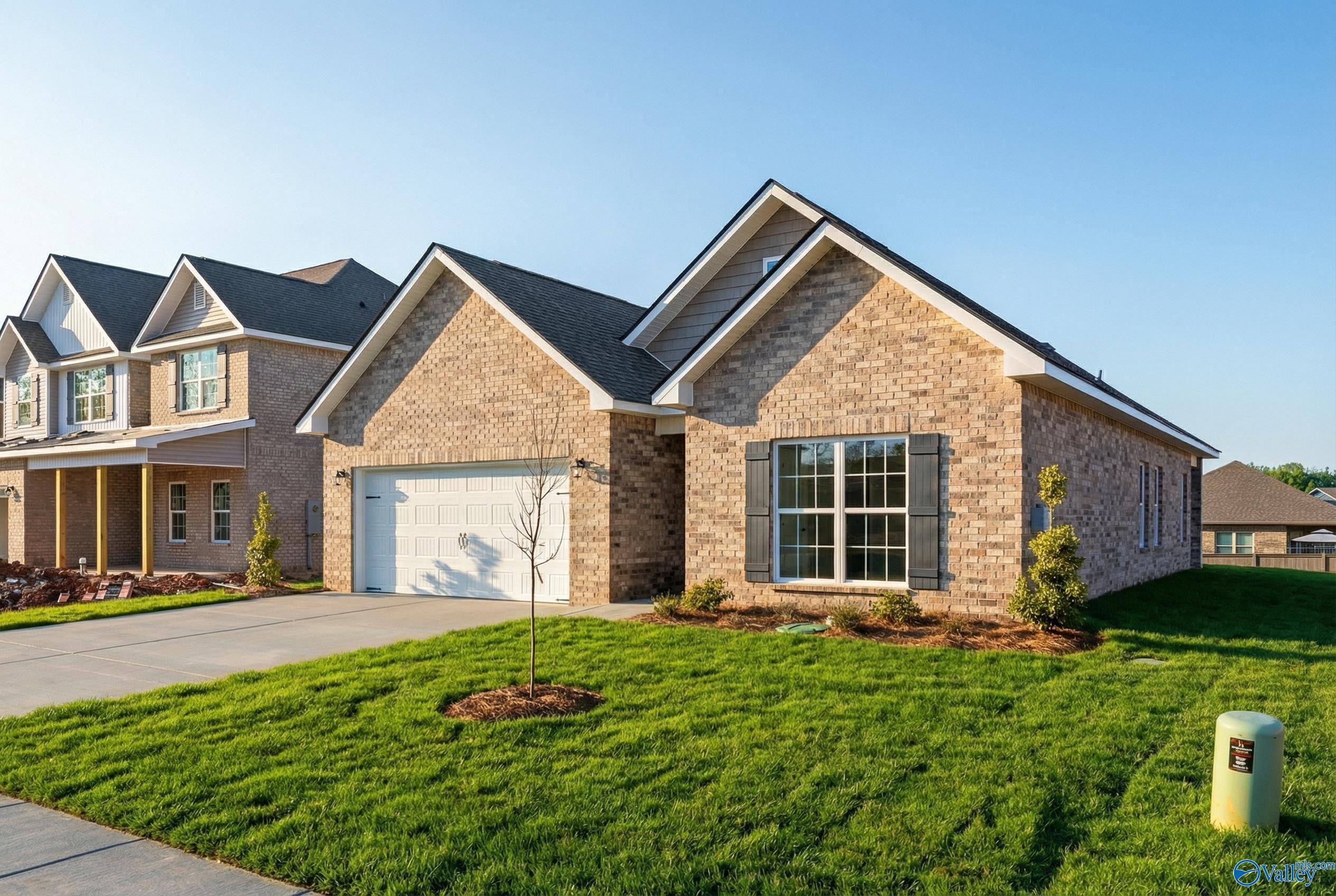 Brick ranch home with 2-car garage, brick facade, large windows, and lush front yard in Creek Grove, New Market, Alabama