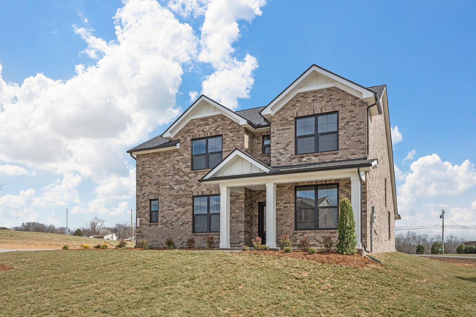Two-story brick home with gabled roof, white-columned porch, and garage in Benders Cove, Mt. Juliet, Tennessee
