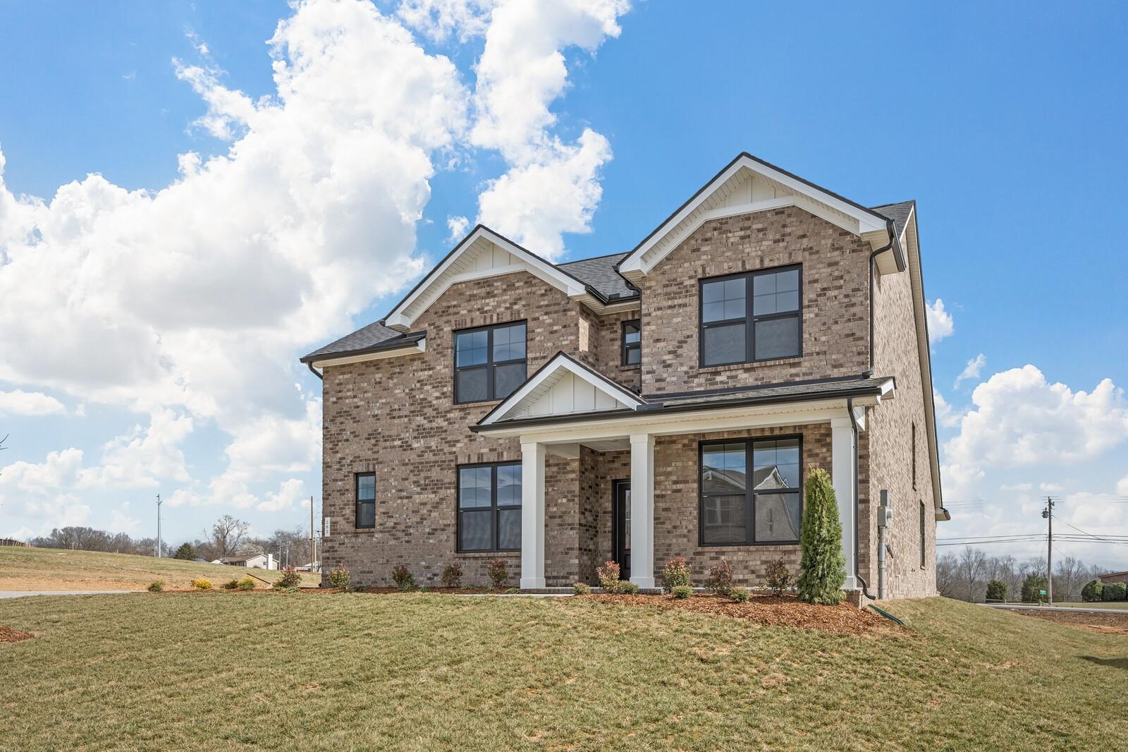 Two-story brick home with gabled roof, white-columned porch, and garage in Benders Cove, Mt. Juliet, Tennessee