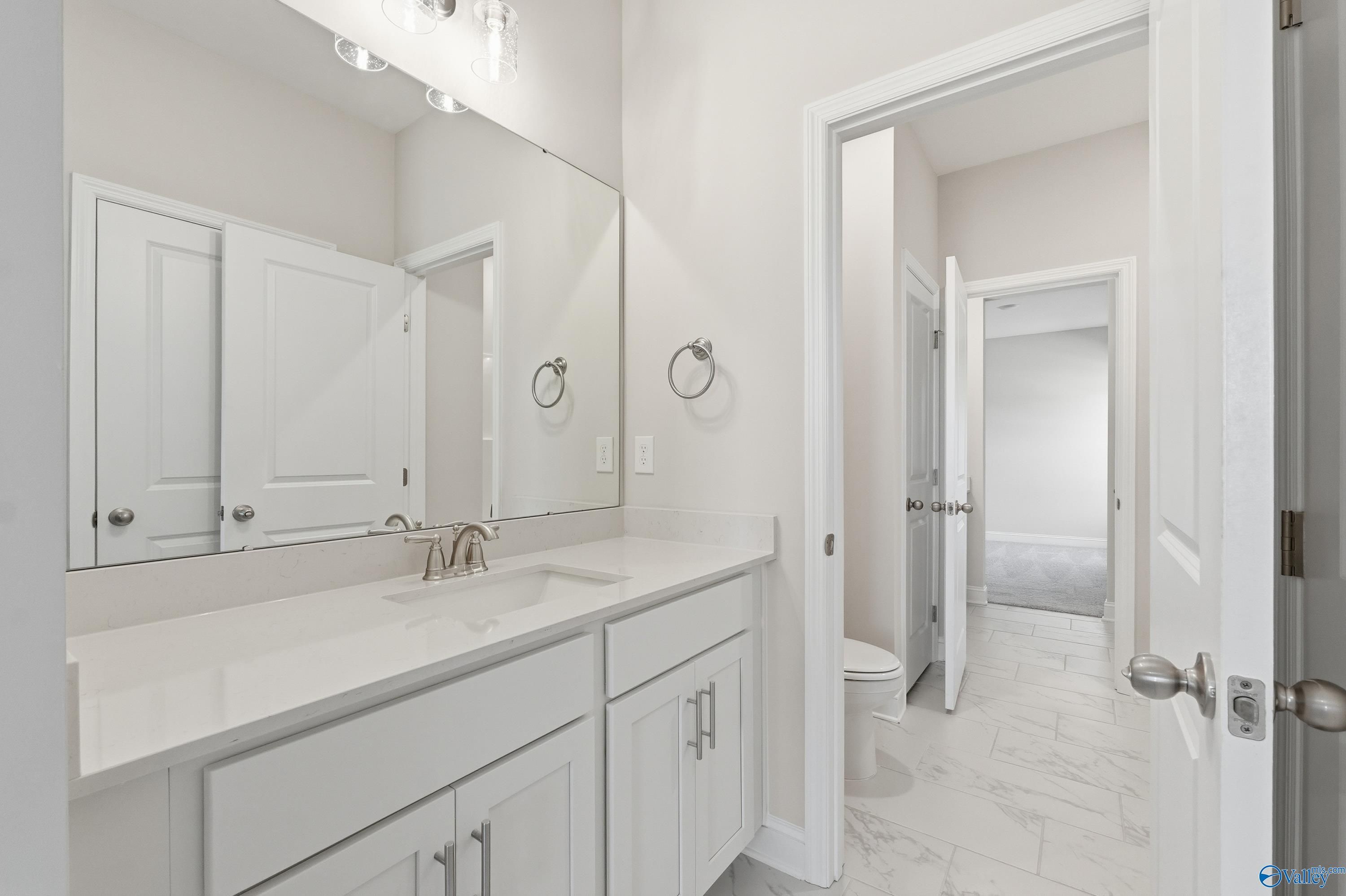 Elegant master bathroom featuring double vanity, frameless mirror, and white cabinetry in Davidson Homes The Finleigh, Harvest, Alabama