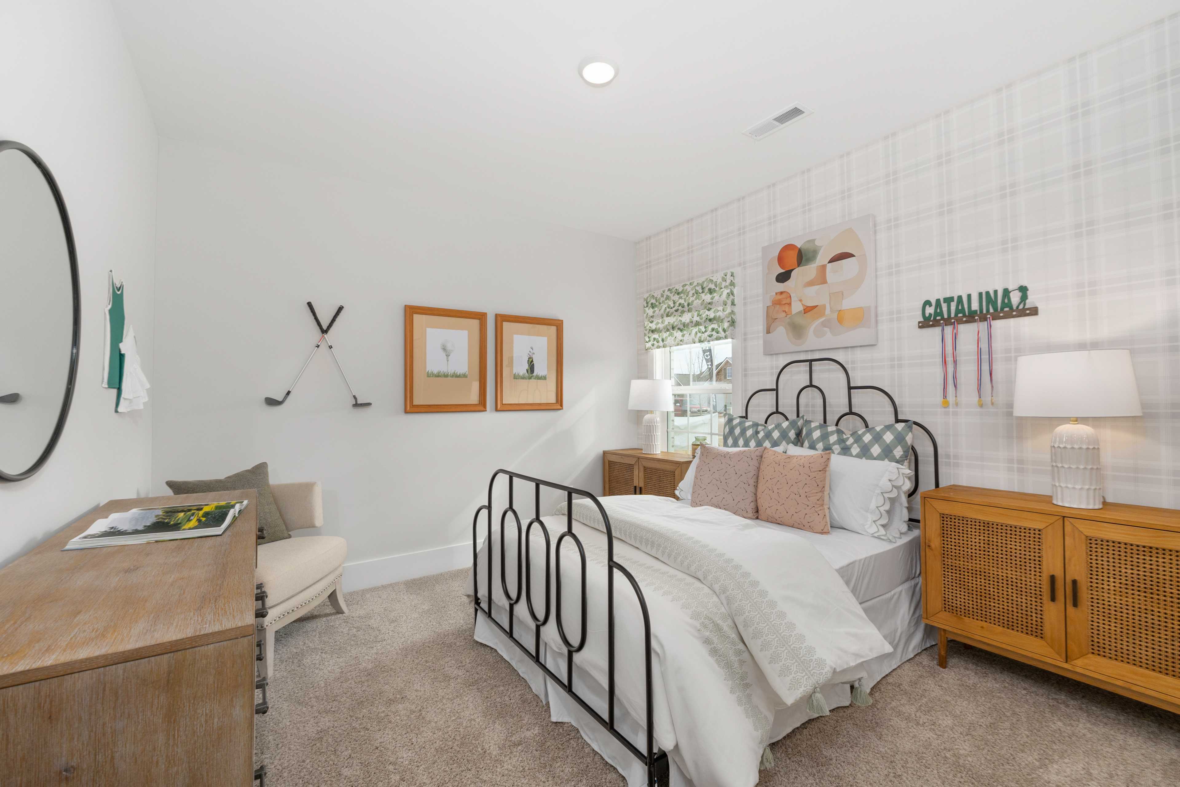Stylish bedroom interior at Briercreek in Meridianville, Alabama featuring iron bed frame, golf decor, and rattan nightstands