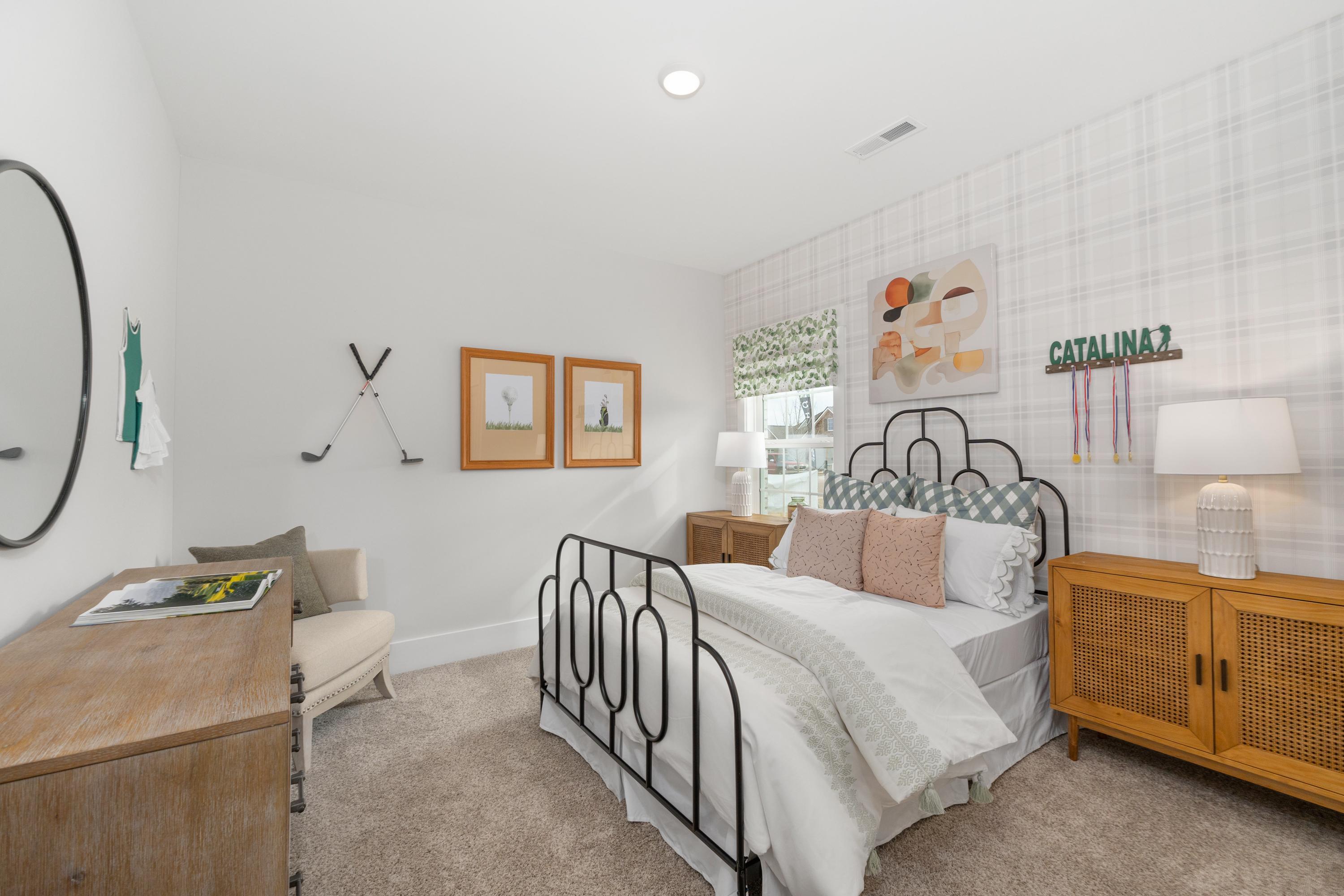 Stylish bedroom interior at Briercreek in Meridianville, Alabama featuring iron bed frame, golf decor, and rattan nightstands