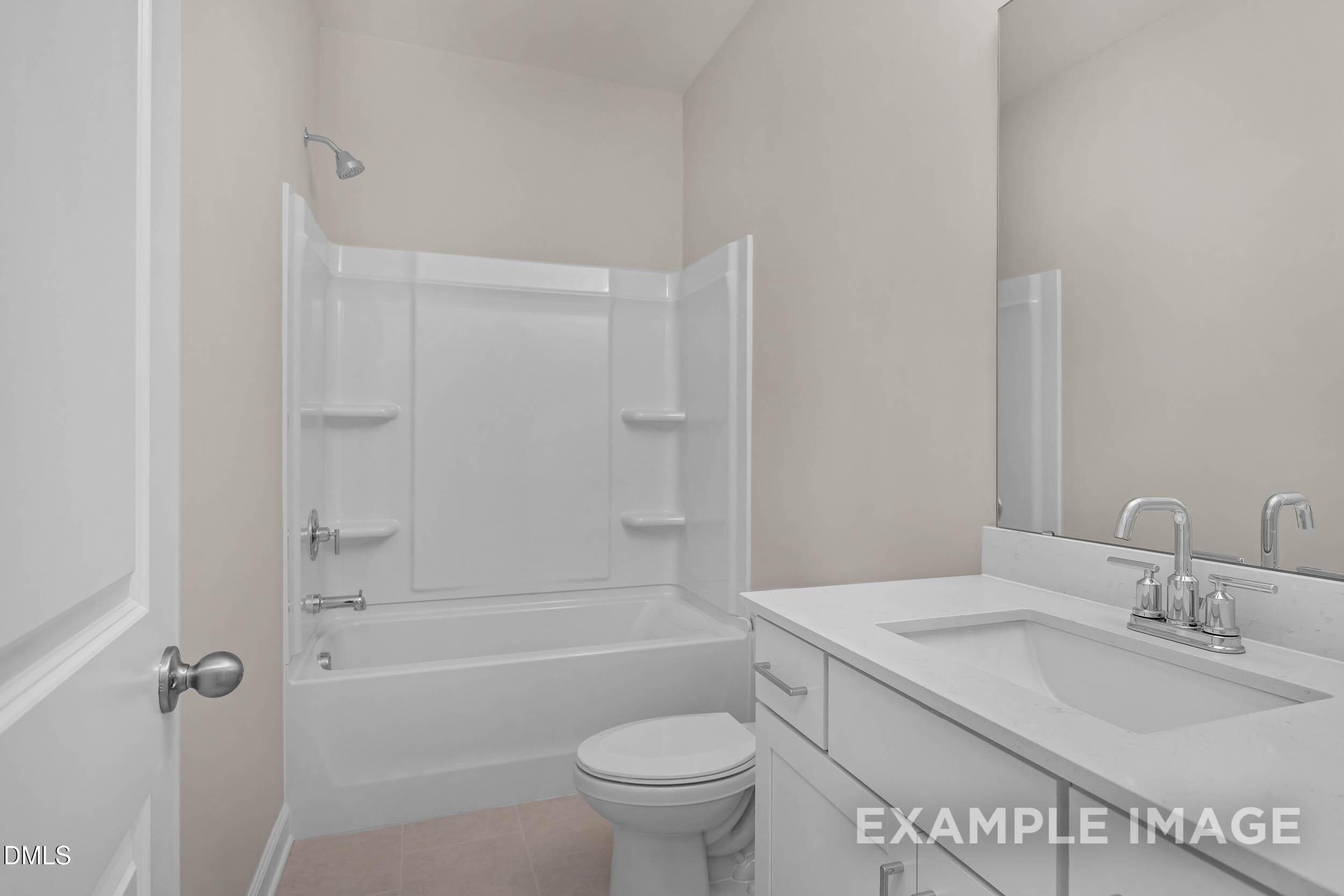 Modern bathroom with white vanity, quartz countertop, and tub-shower combo in The Franklin C home, Retreat at North Main.