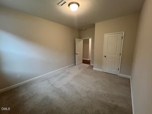 Spacious carpeted bedroom with neutral walls and closet in The Willow D by Davidson Homes at Wellers Knoll, Lillington, NC
