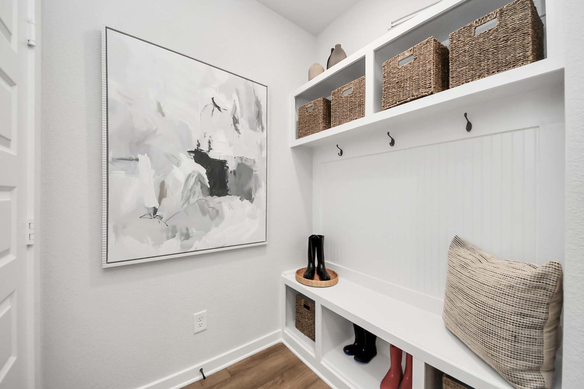 Mudroom entry with built-in bench, storage baskets, and coat hooks at The Enclave at Newport in Crosby, Texas.