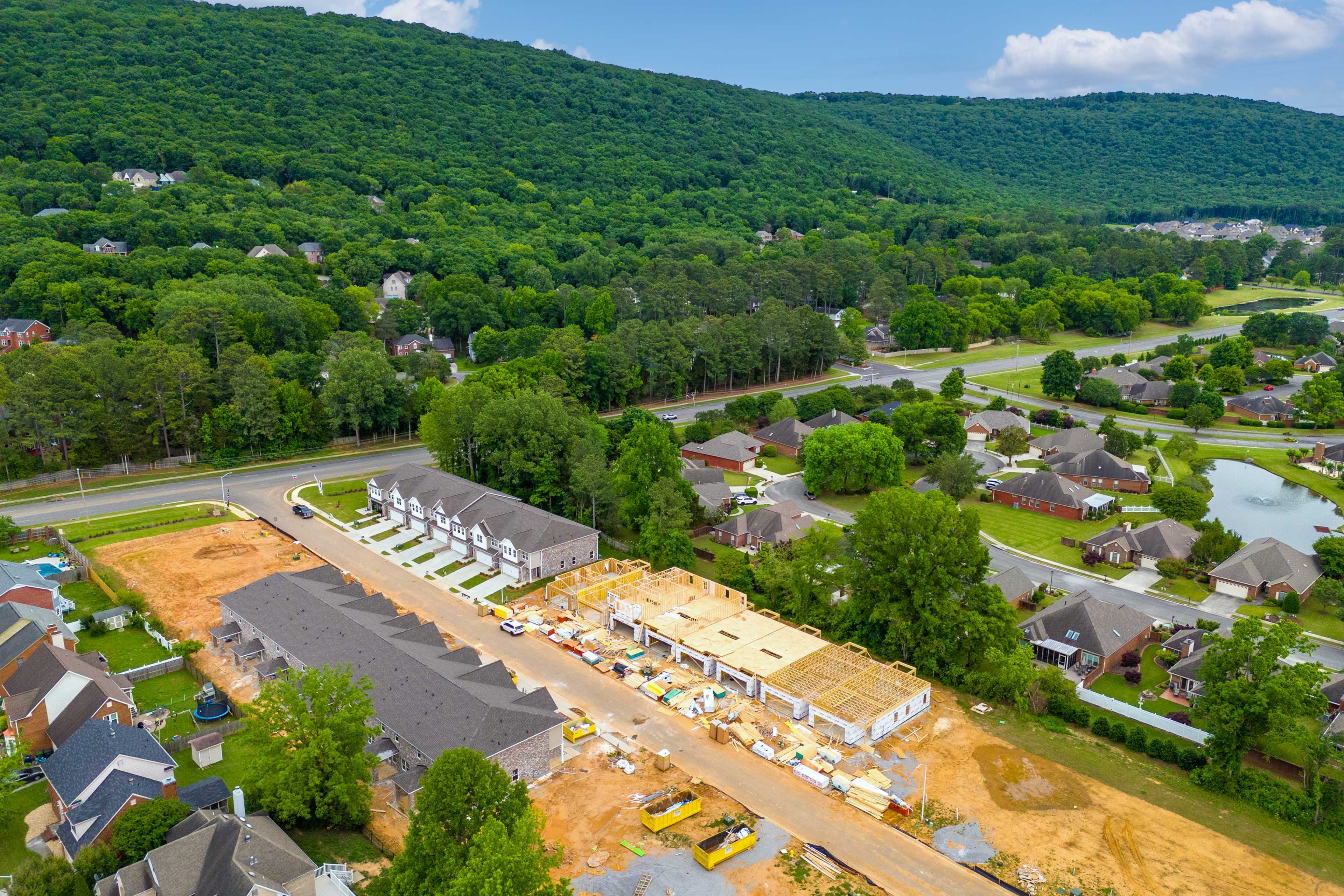 New townhome construction at Pavilion in Huntsville AL by Davidson Homes amid green forests and hills