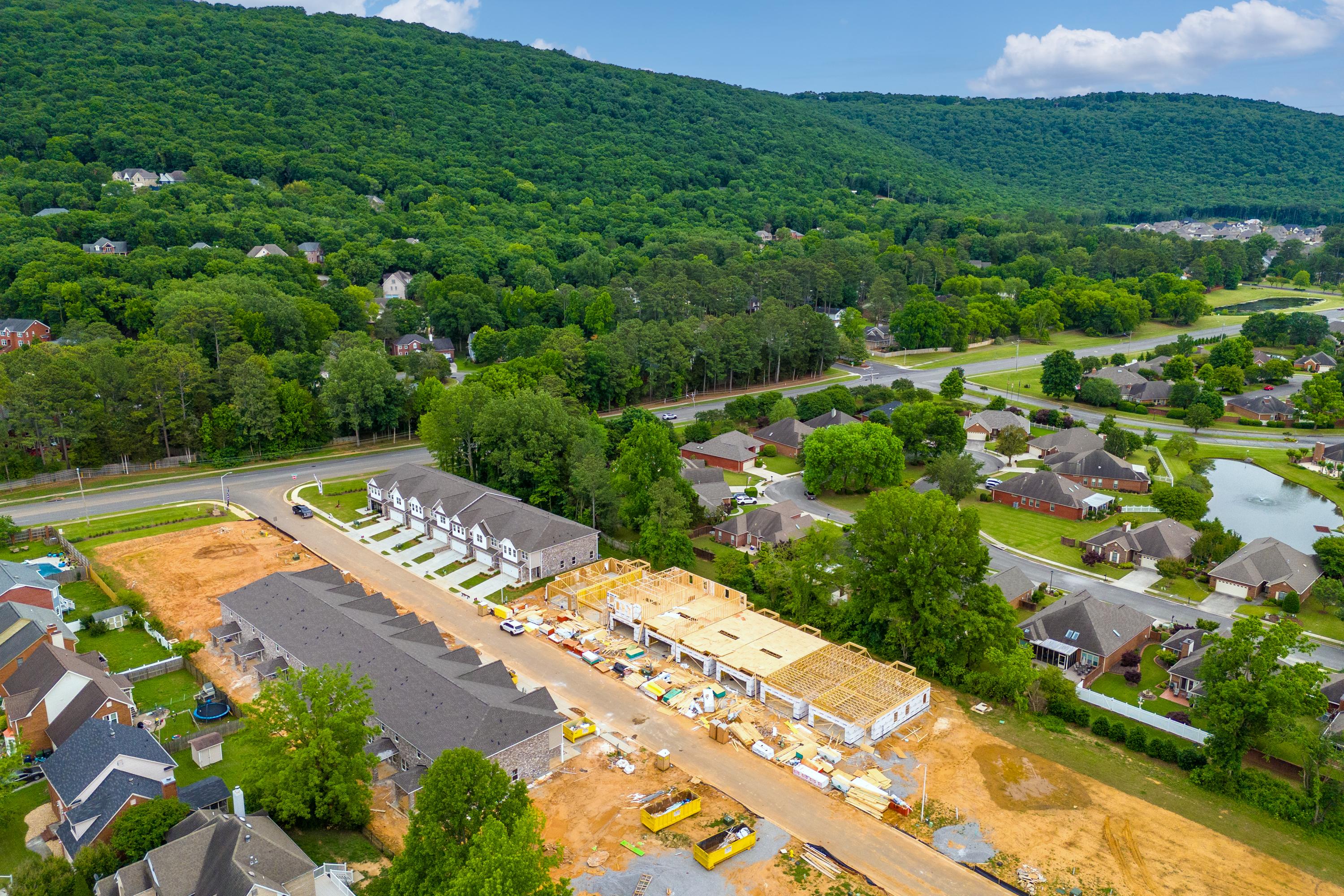 New townhome construction at Pavilion in Huntsville AL by Davidson Homes amid green forests and hills