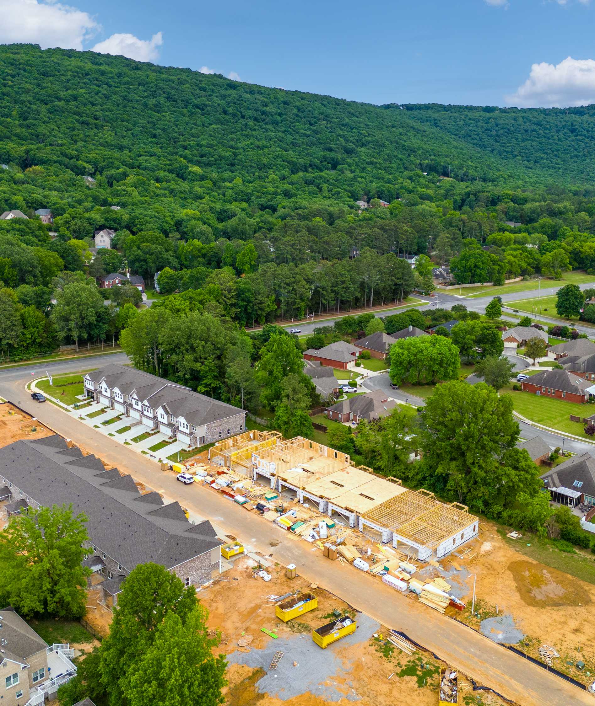 Aerial view of townhome construction at The Pavilion in Huntsville AL amid lush forests hills and nearby homes