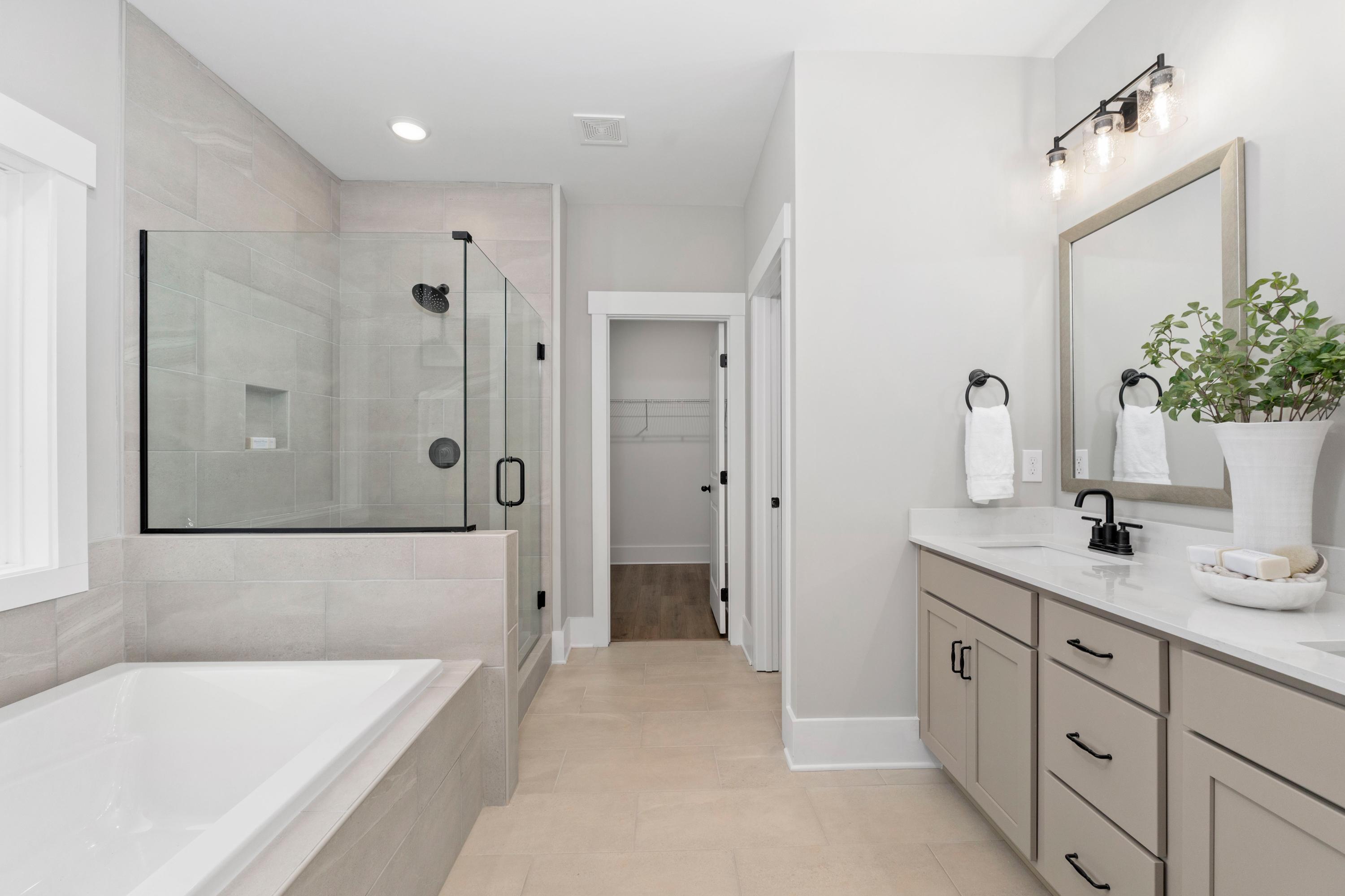 Spacious modern master bathroom at Little Creek in Arab Alabama with frameless glass shower, freestanding tub and double vanity