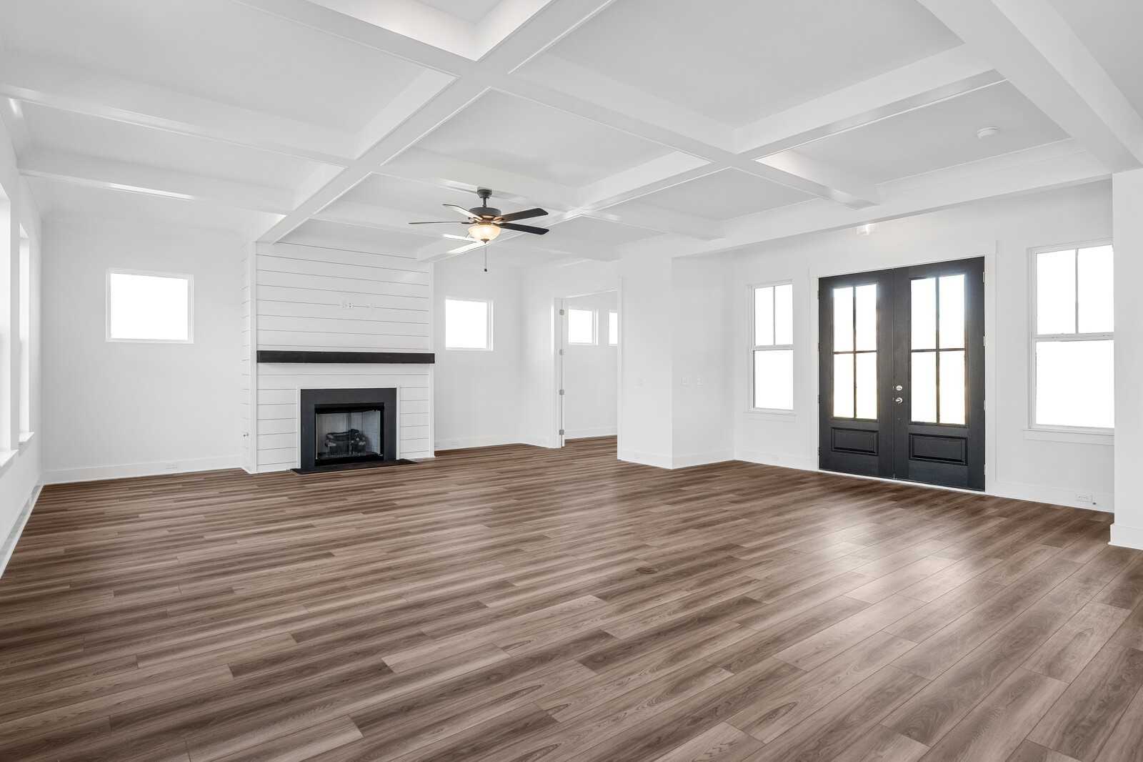 Spacious living room with shiplap fireplace, coffered ceiling fan, hardwood floors in Davidson Homes The Alston A, Murfreesboro