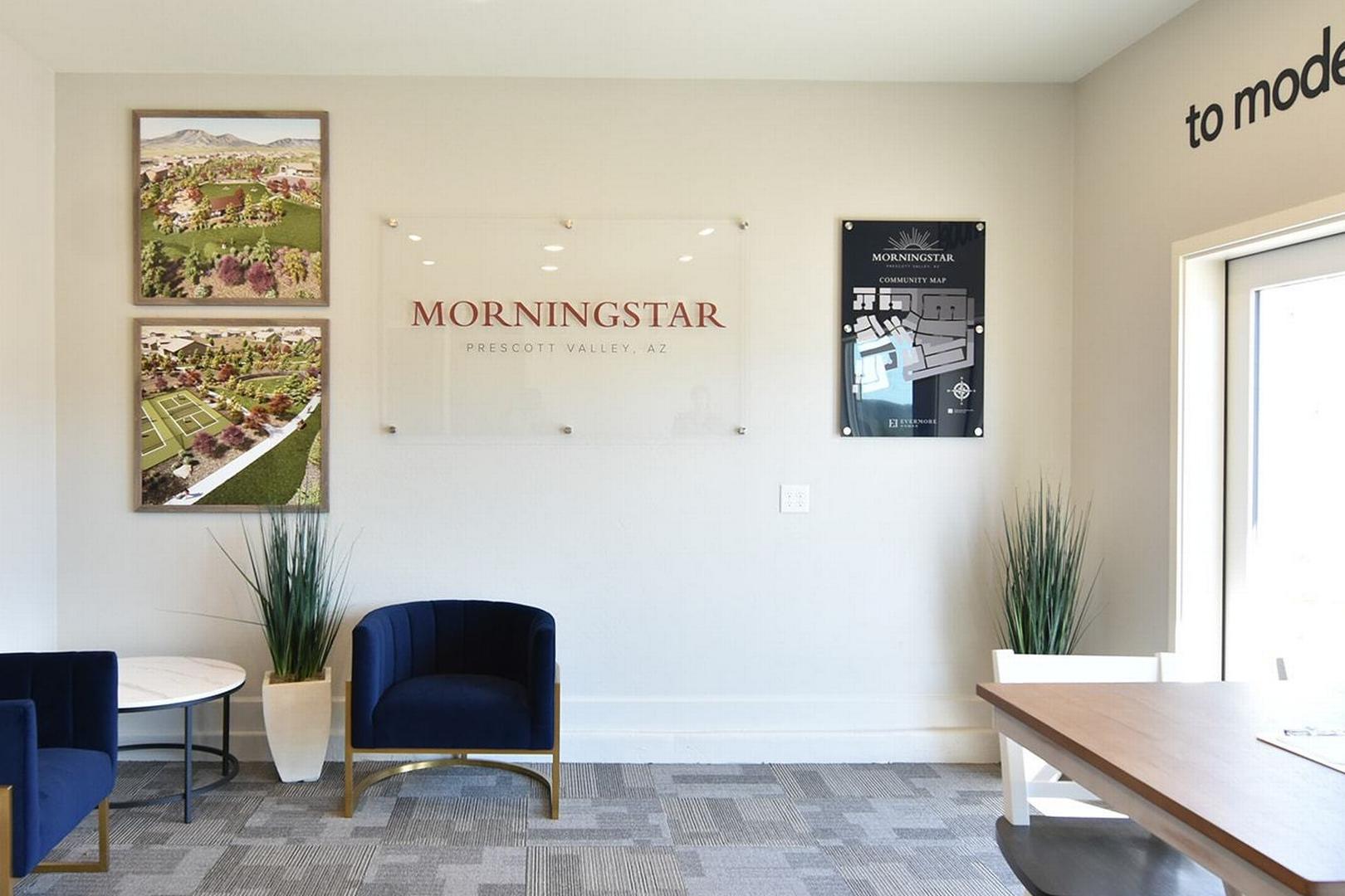 Welcoming reception in The Summit E model home with Morningstar branding, scenic mountain frames, blue velvet chairs, and brochure table