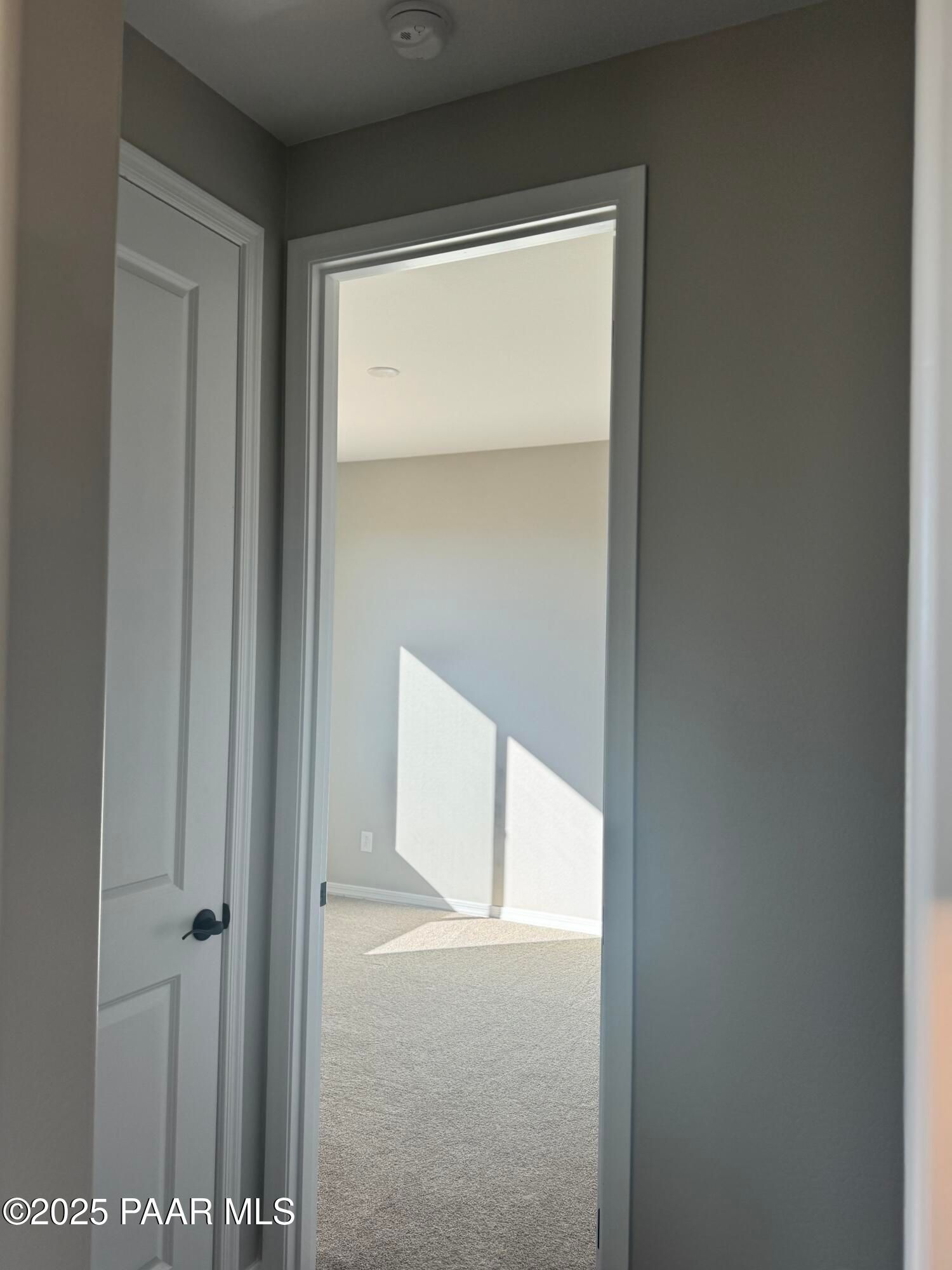 Open doorway to sunlit carpeted hallway in 3-bedroom Davidson Homes The Monarch E, Prescott Arizona