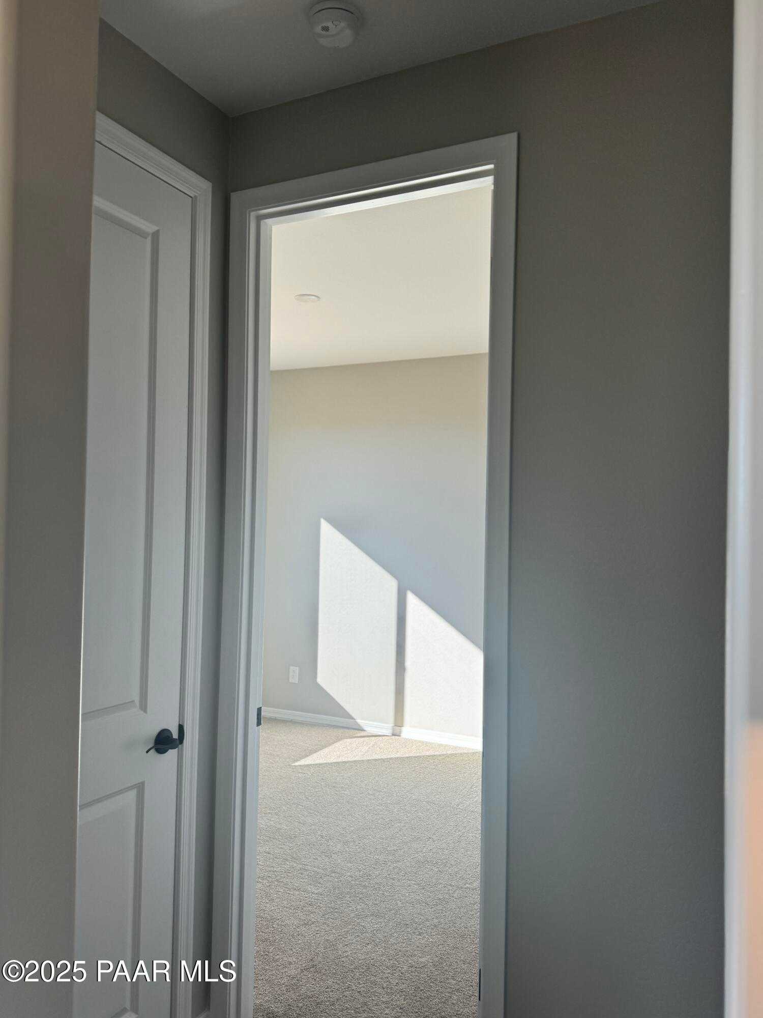 Open doorway to sunlit carpeted hallway in 3-bedroom Davidson Homes The Monarch E, Prescott Arizona