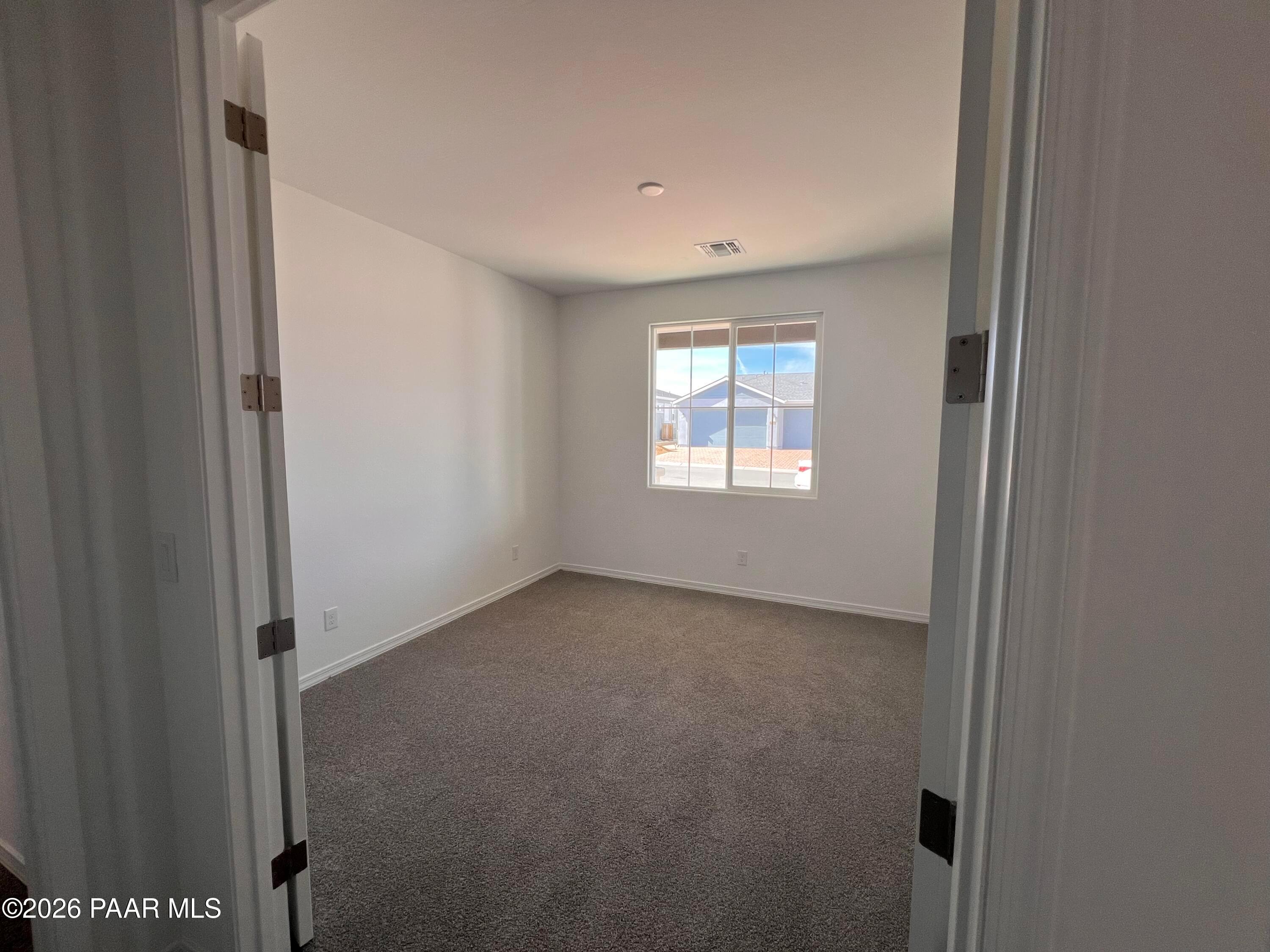 Empty secondary bedroom with white walls, gray carpet, and window blinds in Davidson Homes The Summit A, Prescott, Arizona