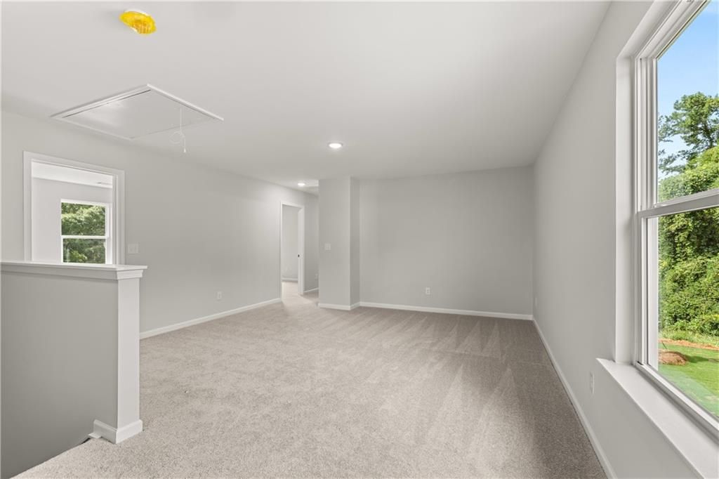 Spacious carpeted loft area in The Russell A floor plan at Cedar Farms in Winder, Georgia.