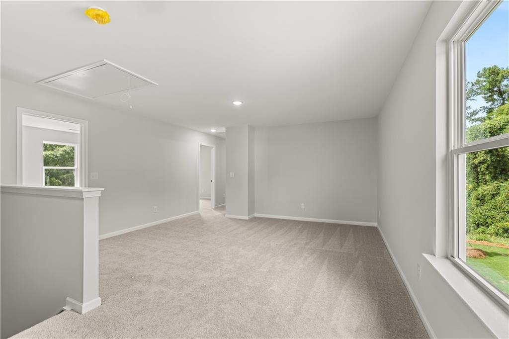 Spacious carpeted loft area in The Russell A floor plan at Cedar Farms in Winder, Georgia.