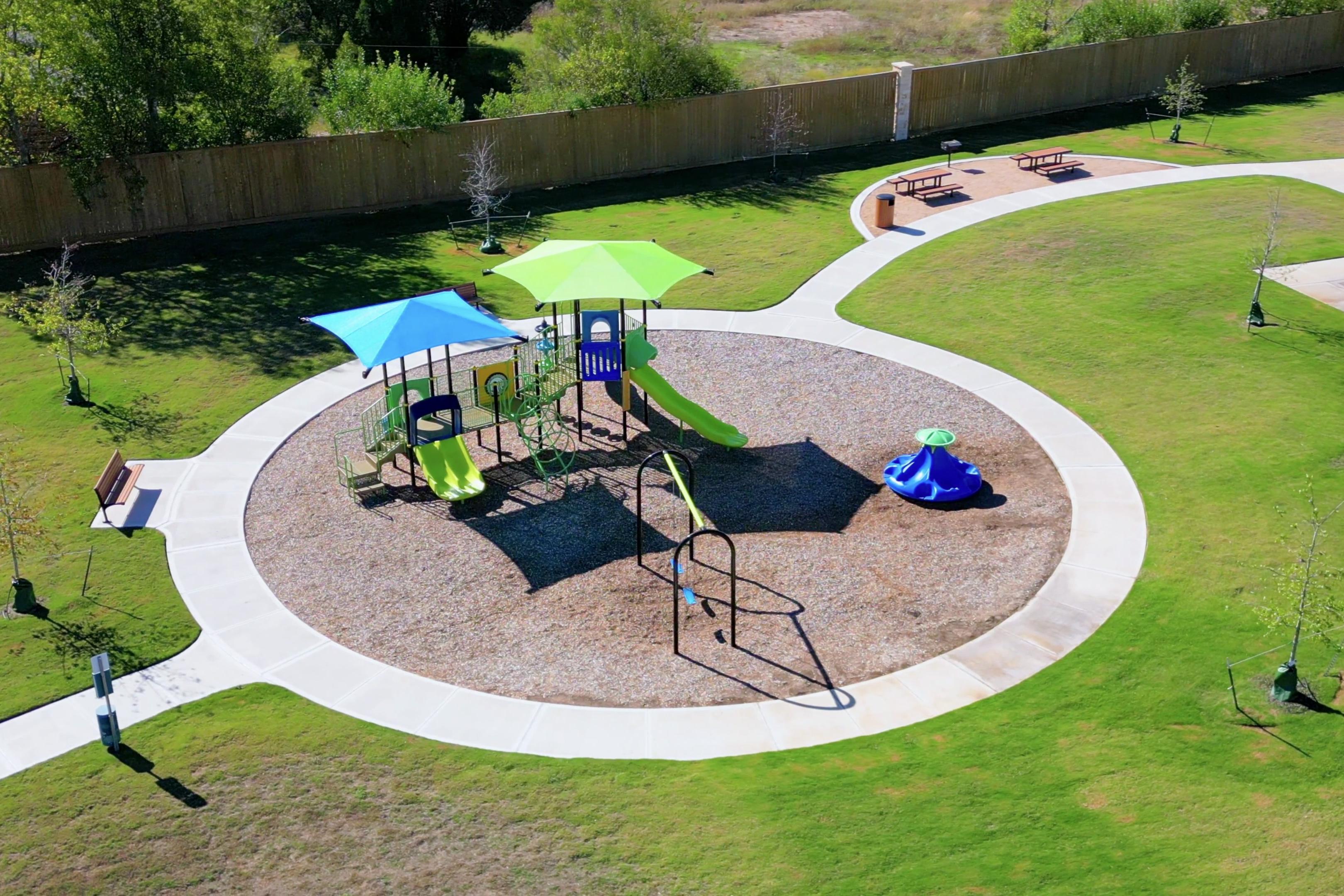 Vibrant playground with colorful slides, swings, and shaded play structures at Applewhite Meadows in San Antonio, Texas