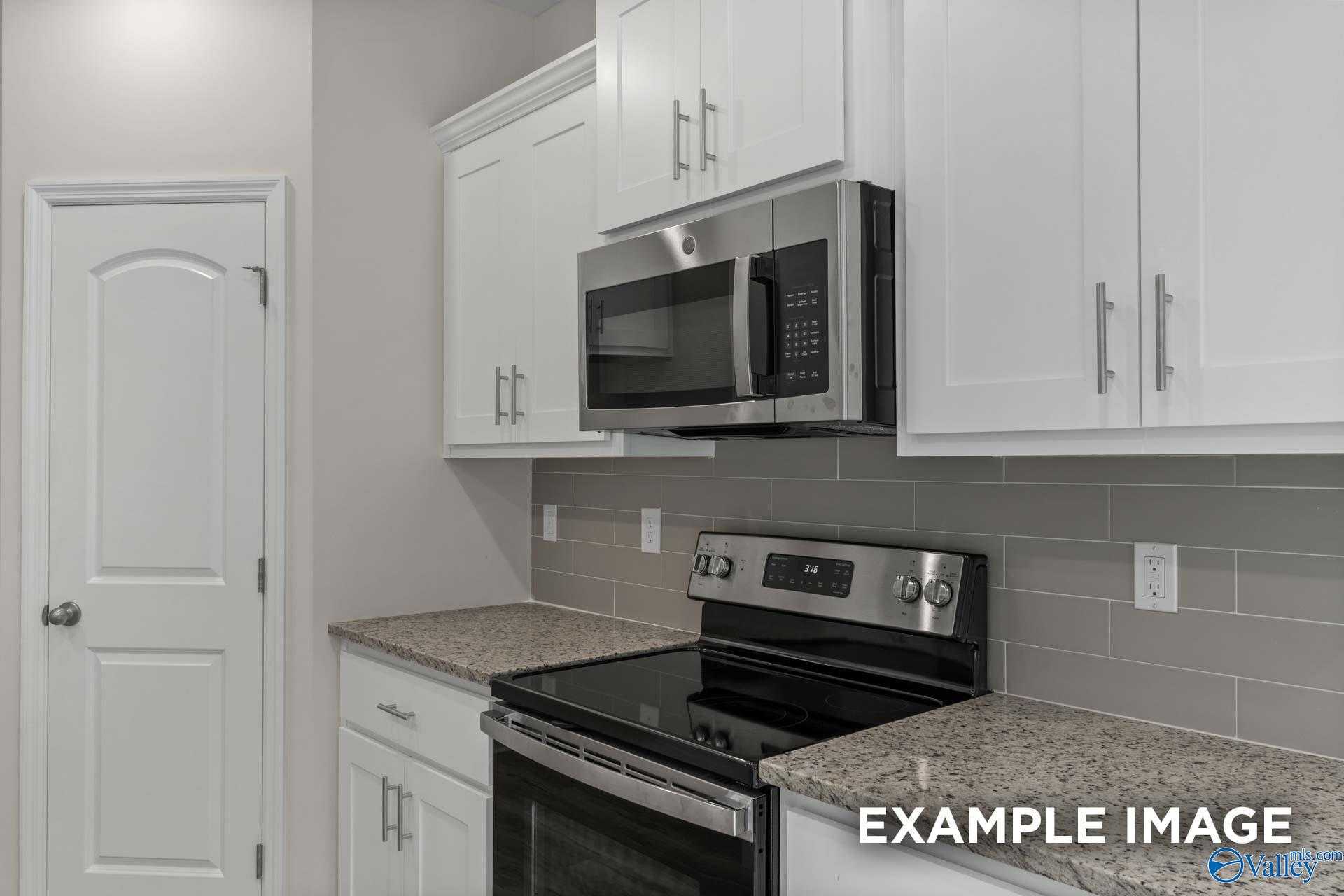 Modern kitchen featuring white cabinets, granite countertops, stainless steel appliances in Davidson Homes The Butler, Toney, Alabama