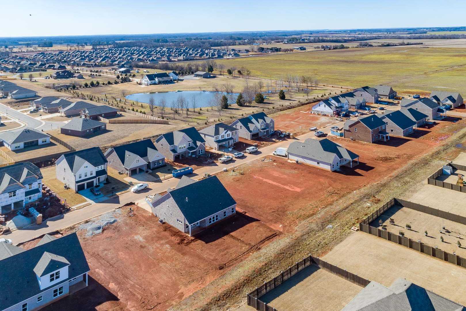 Aerial view of new homes in Old Stone community, Athens Alabama by Davidson Homes with pond and construction sites