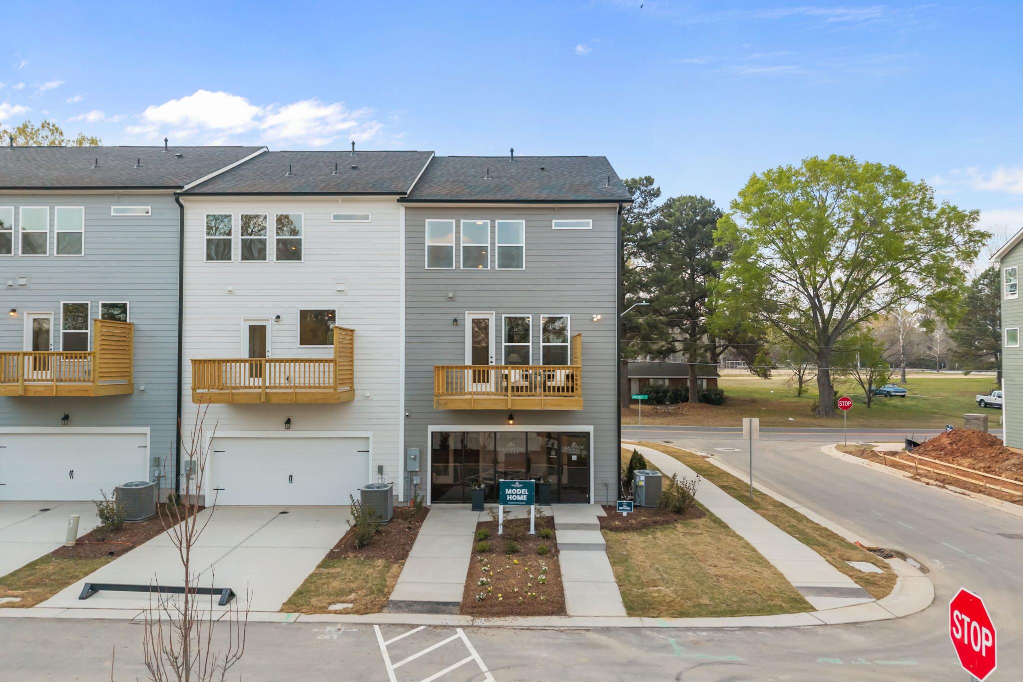Modern townhomes at Camden Park in Knightdale, NC with gray-white exteriors, wooden balconies, and garages