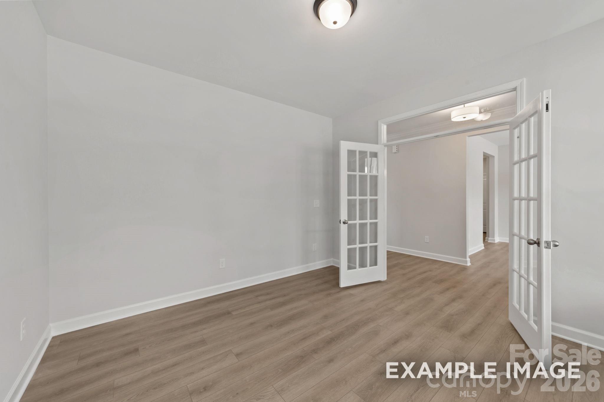 Bright home office or flex room with French doors and wood-look flooring in The Magnolia B plan, Windgate, Mooresville.
