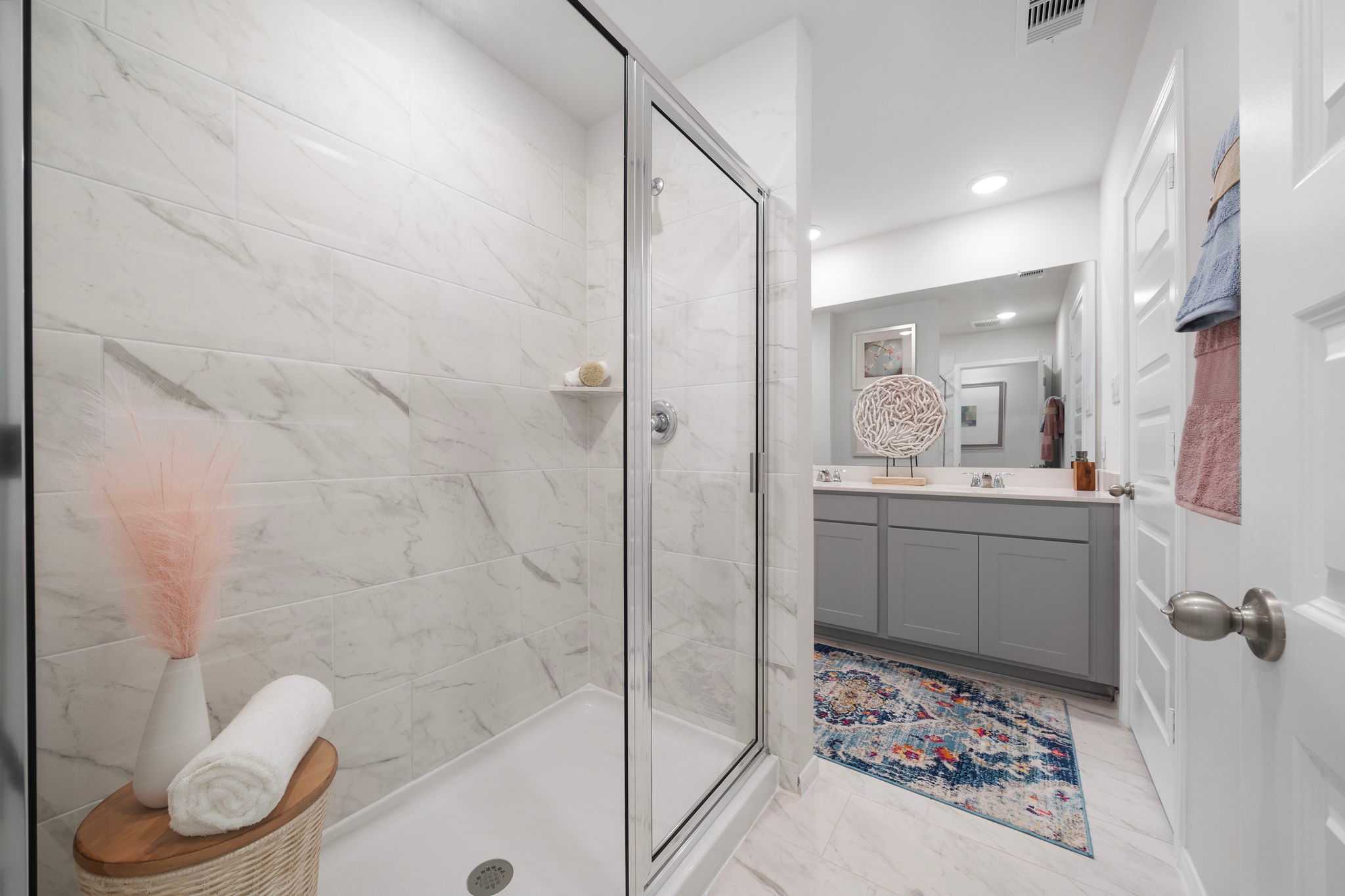 Spacious primary bathroom at Hill & Dale Ranch in Splendora, Texas with white marble shower and double vanity