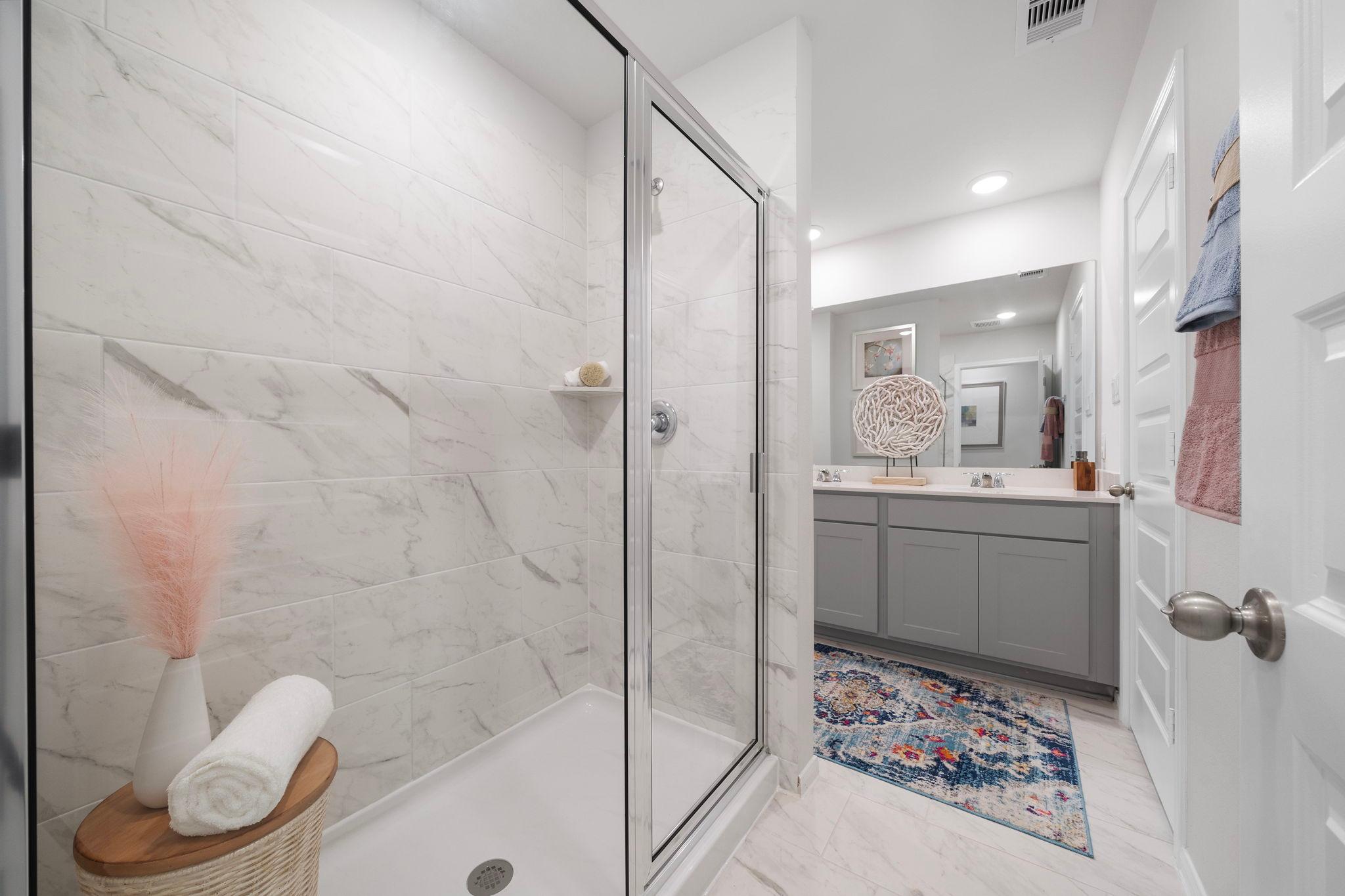 Spacious primary bathroom at Hill & Dale Ranch in Splendora, Texas with white marble shower and double vanity