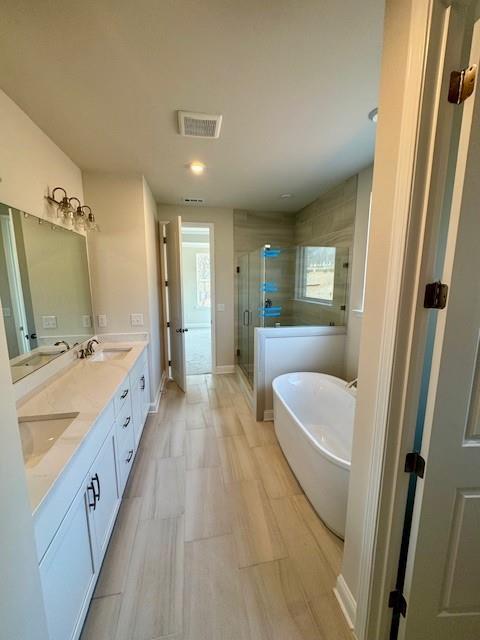 Elegant master bathroom featuring double vanity, freestanding tub, and glass shower in Davidson Homes The Danbury C, Buford, GA