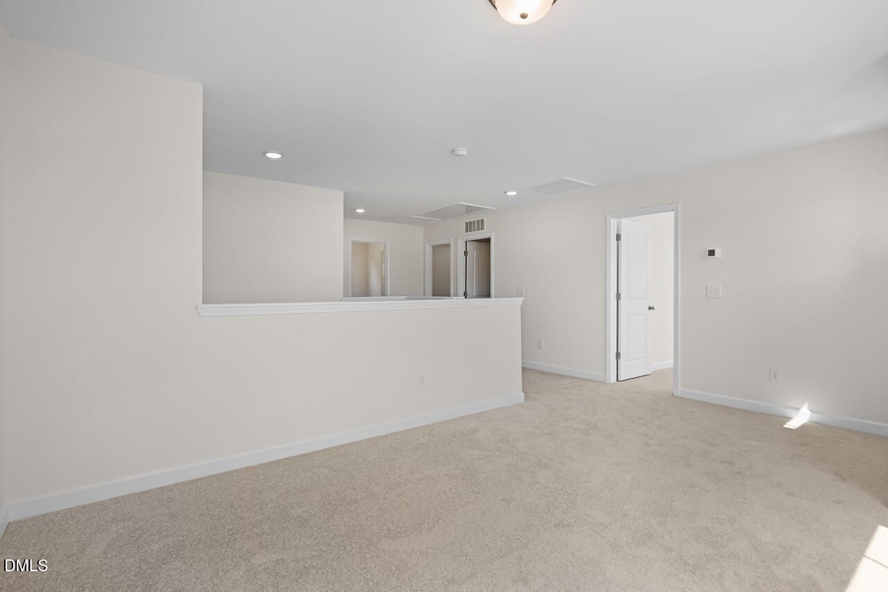 Spacious carpeted loft with half wall overlooking lower level in Davidson Homes The Willow B, Woodland Crossing, Zebulon NC