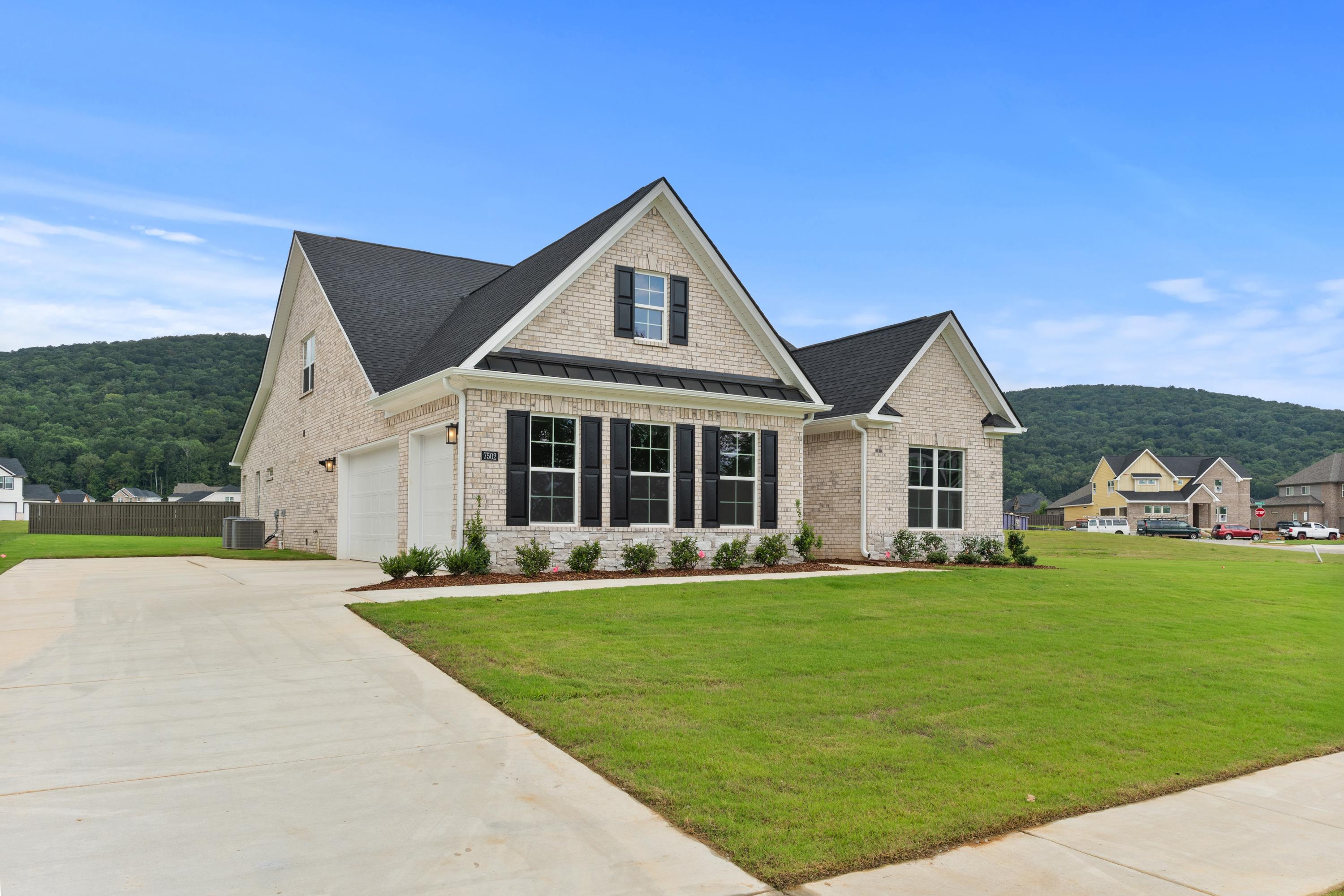 The Oxford 2-story brick home exterior with gabled roof, black shutters, 3-car garage, and landscaped yard in Owens Cross Roads