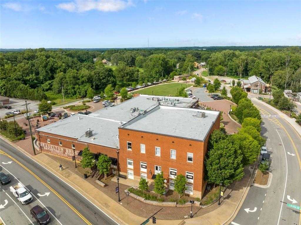 Aerial view of brick building surrounded by lush green trees, roads, and landscapes in Wehunt Meadows, Hoschton, Georgia, near Davidson Homes