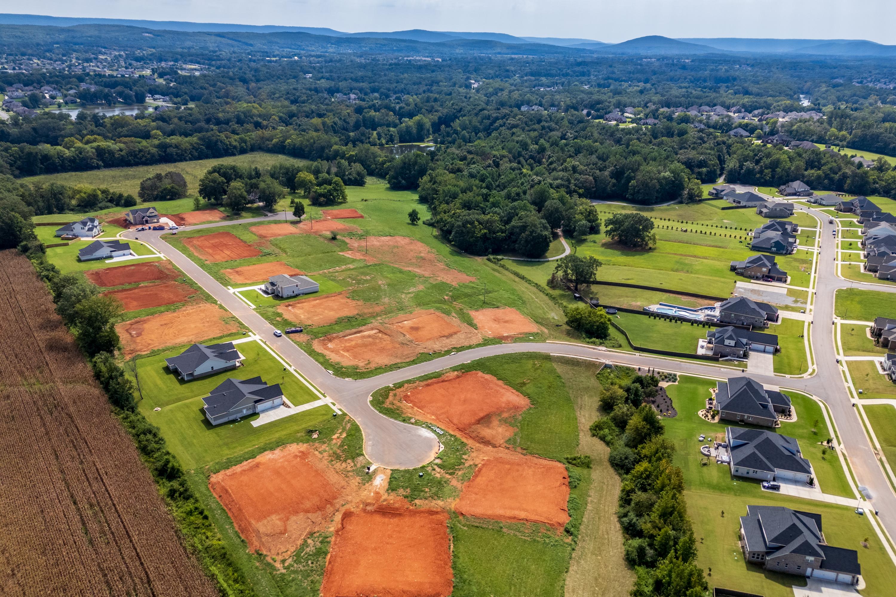 Aerial view of Riverton Preserve in Huntsville Alabama showing new Davidson Homes construction sites amid green fields and woods
