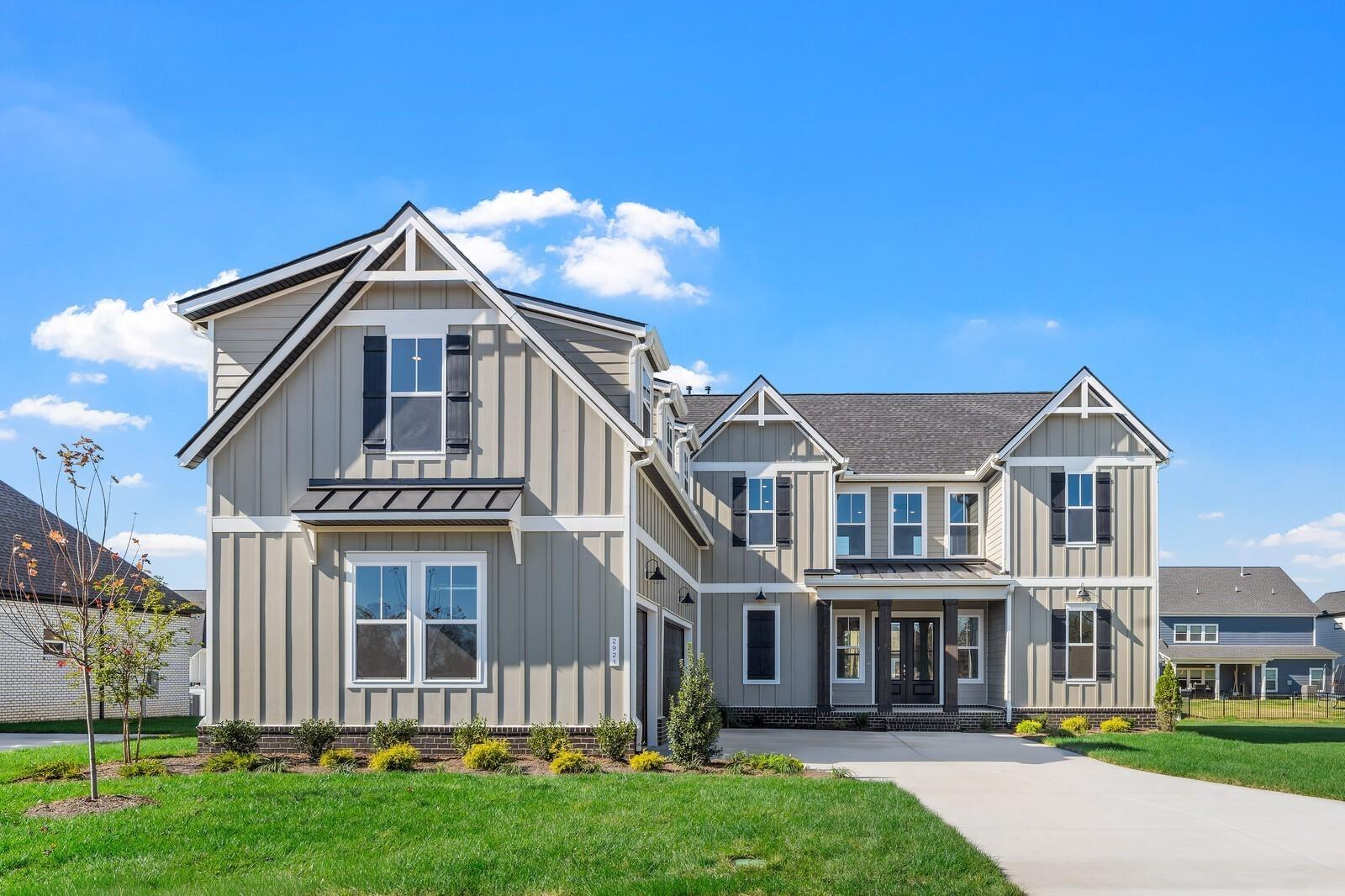 Modern two-story gray board-and-batten home with covered porch, large windows, and lush lawn in Shelton Square, Murfreesboro, Tennessee - Davidson Homes The Alston A