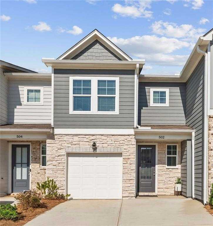Contemporary 2-story Durant A townhome exterior with gray siding, stone accents, and 1-car garage in Stegall Village, Emerson, GA