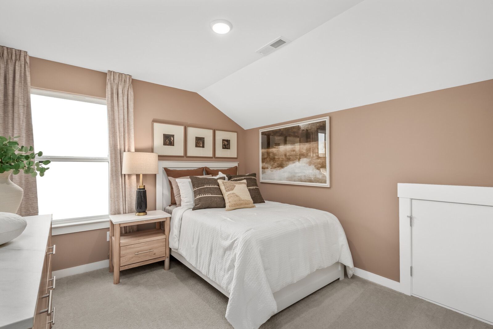 Cozy twin bedroom in Benders Cove Mt. Juliet TN with beige walls, framed artwork, window curtains, and bedside lamp