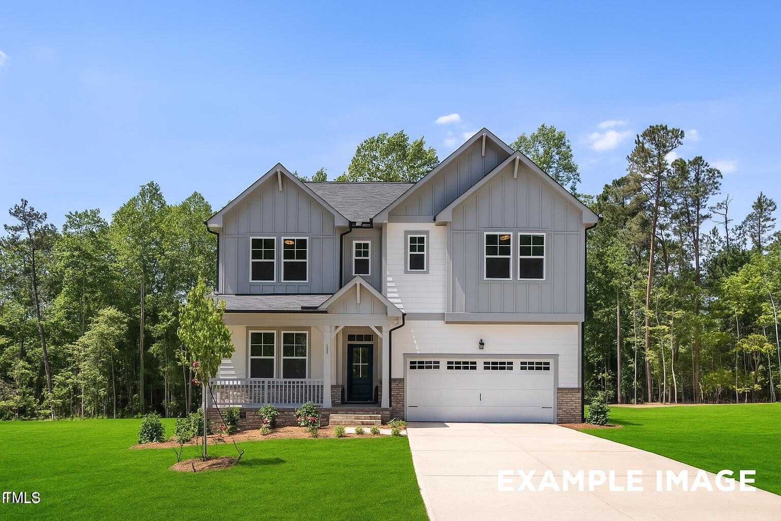 Modern gray craftsman-style 3-story home with 3-car garage, front porch, and lush lawn in Laneridge Estates, Raleigh, NC